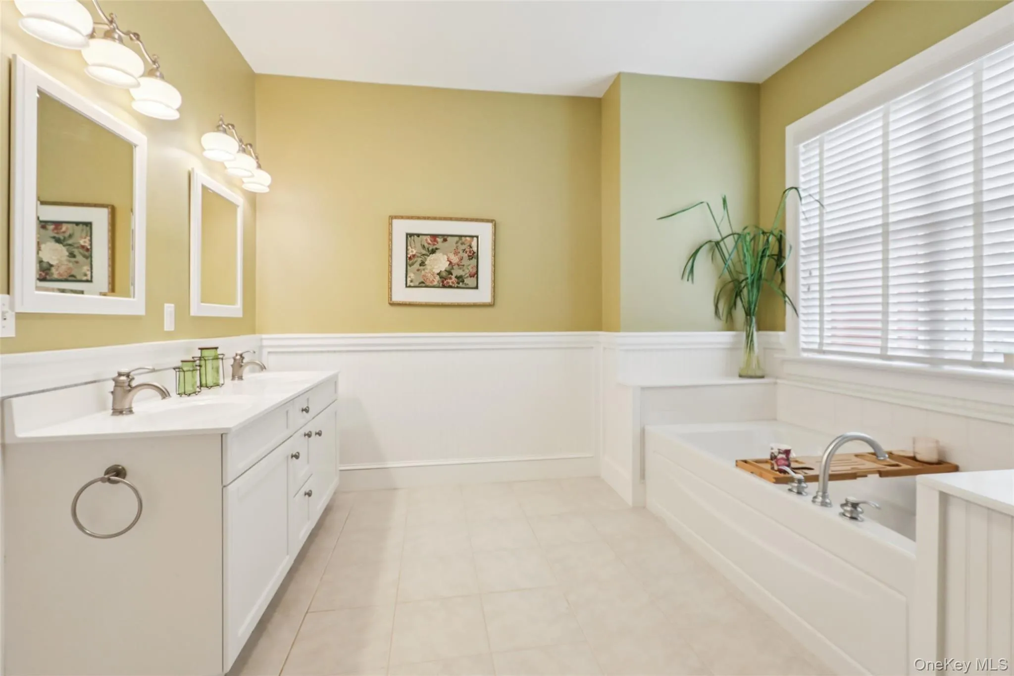 Bathroom with wainscoting, a double vanity, and a soaking tub Bathroom with wainscoting, a double vanity, and a soaking tub