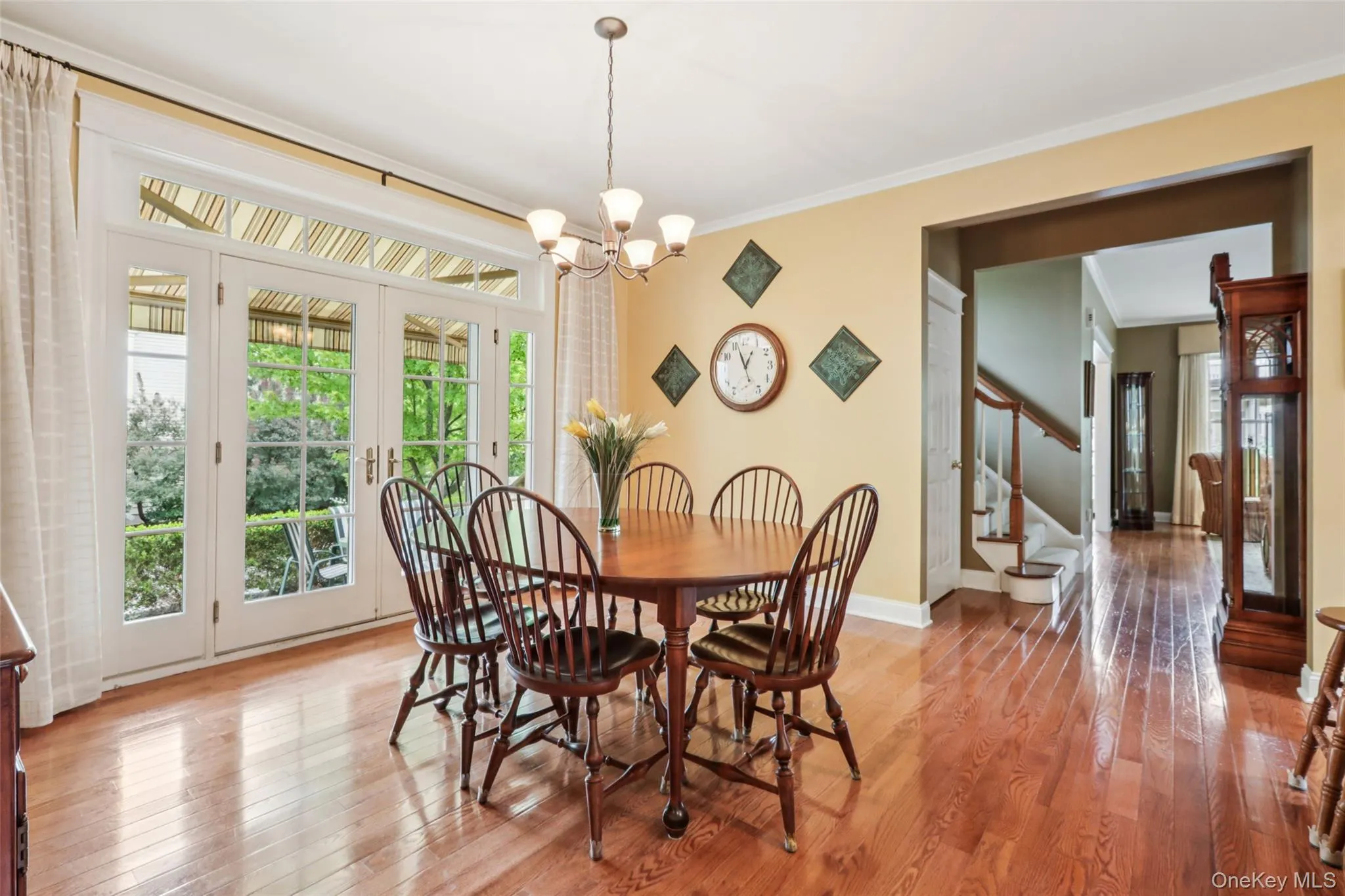 Dining space with crown molding, a chandelier, and french doors leading to the side patio Dining space with crown molding, a chandelier, and french doors leading to the side patio