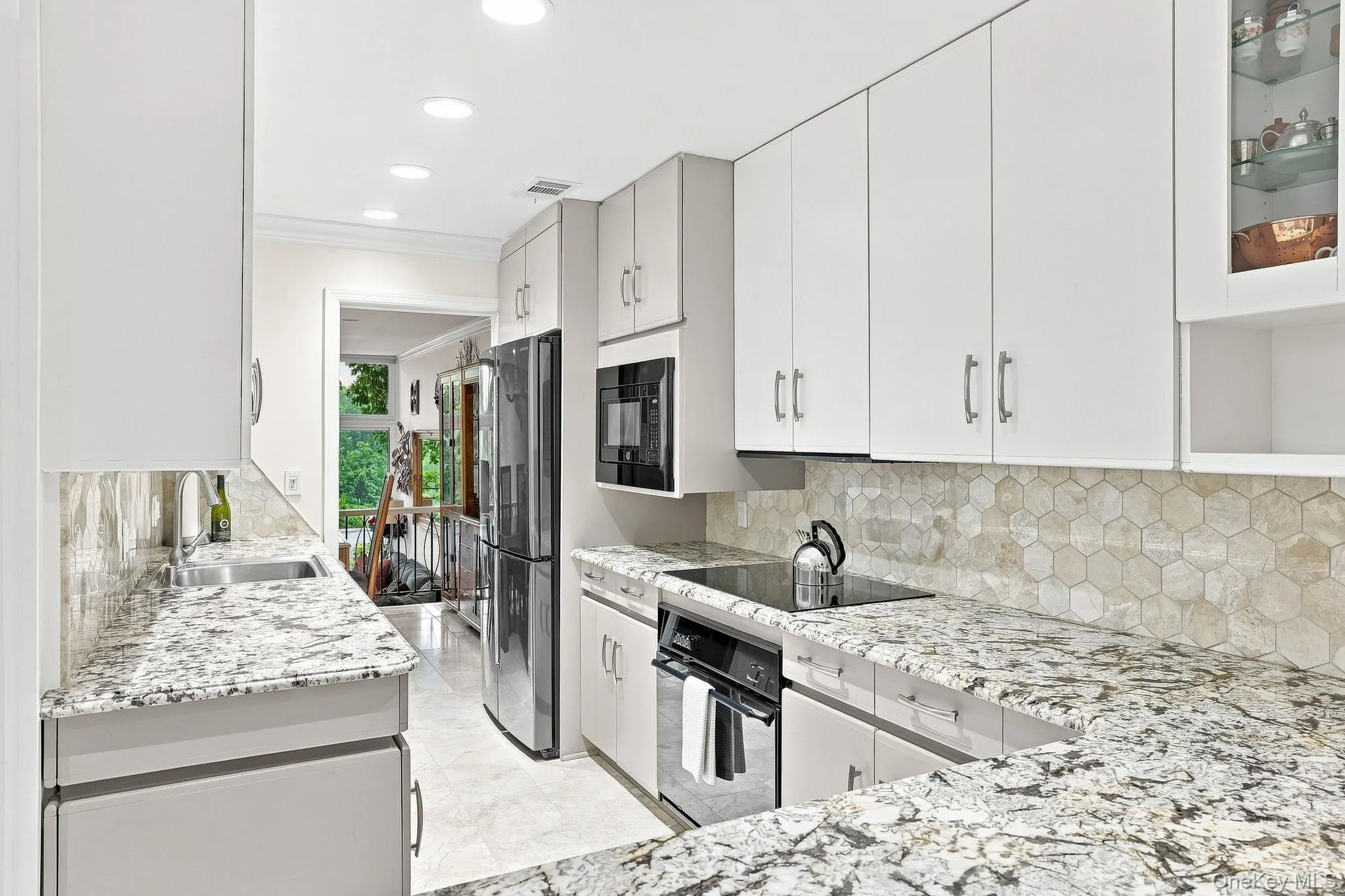 A chef's kitchen with recessed lighting and signature hexagon backsplash tile has ample countertop space for meal preparation A chef's kitchen with recessed lighting and signature hexagon backsplash tile has ample countertop space for meal preparation
