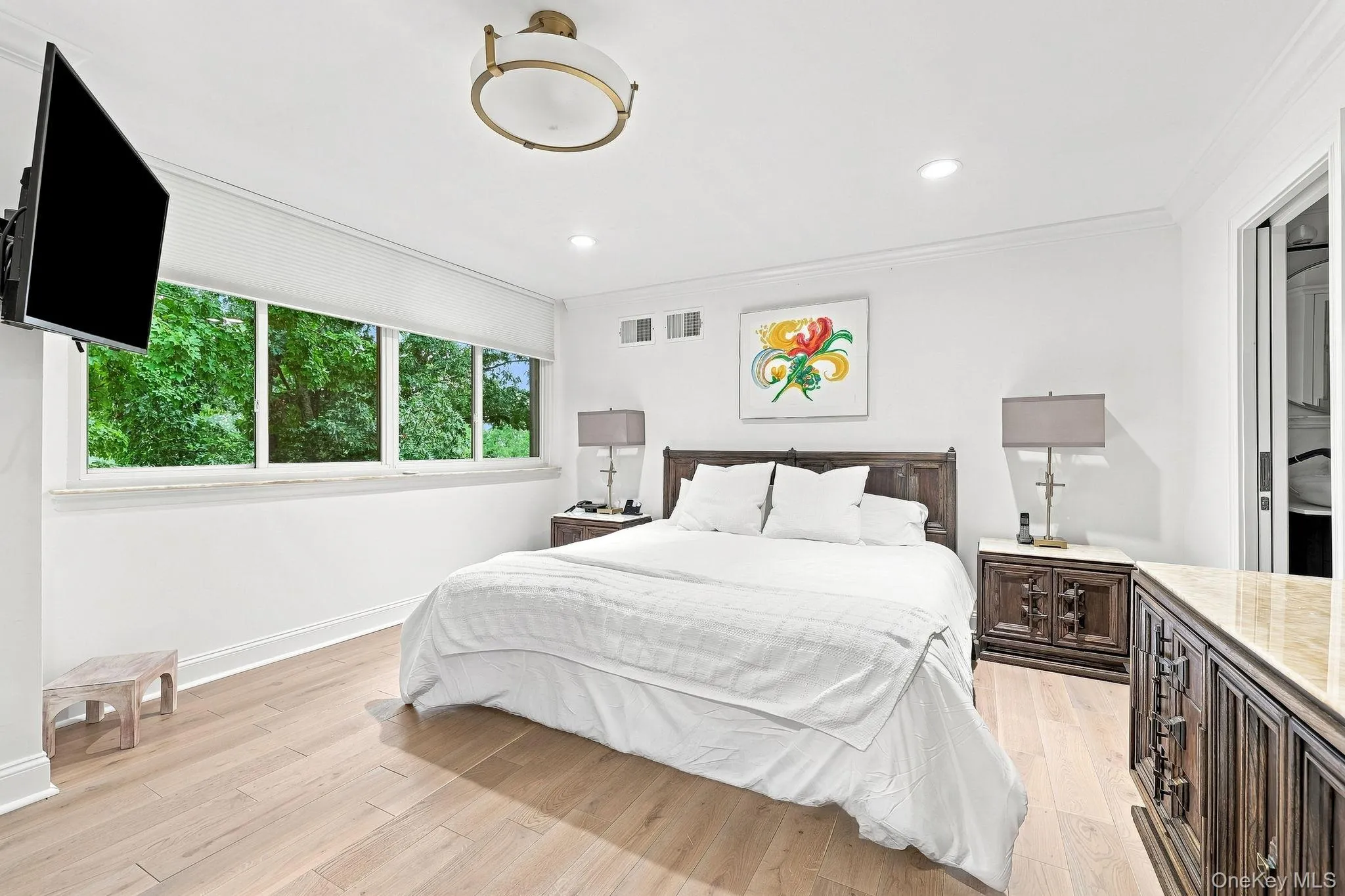 Primary bedroom has magnificent tree top views with Hunter Douglas remote controlled shade, solid white oak flooring, plus recessed and a ceiling fixture lighting Primary bedroom has magnificent tree top views with Hunter Douglas remote controlled shade, solid white oak flooring, plus recessed and a ceiling fixture lighting