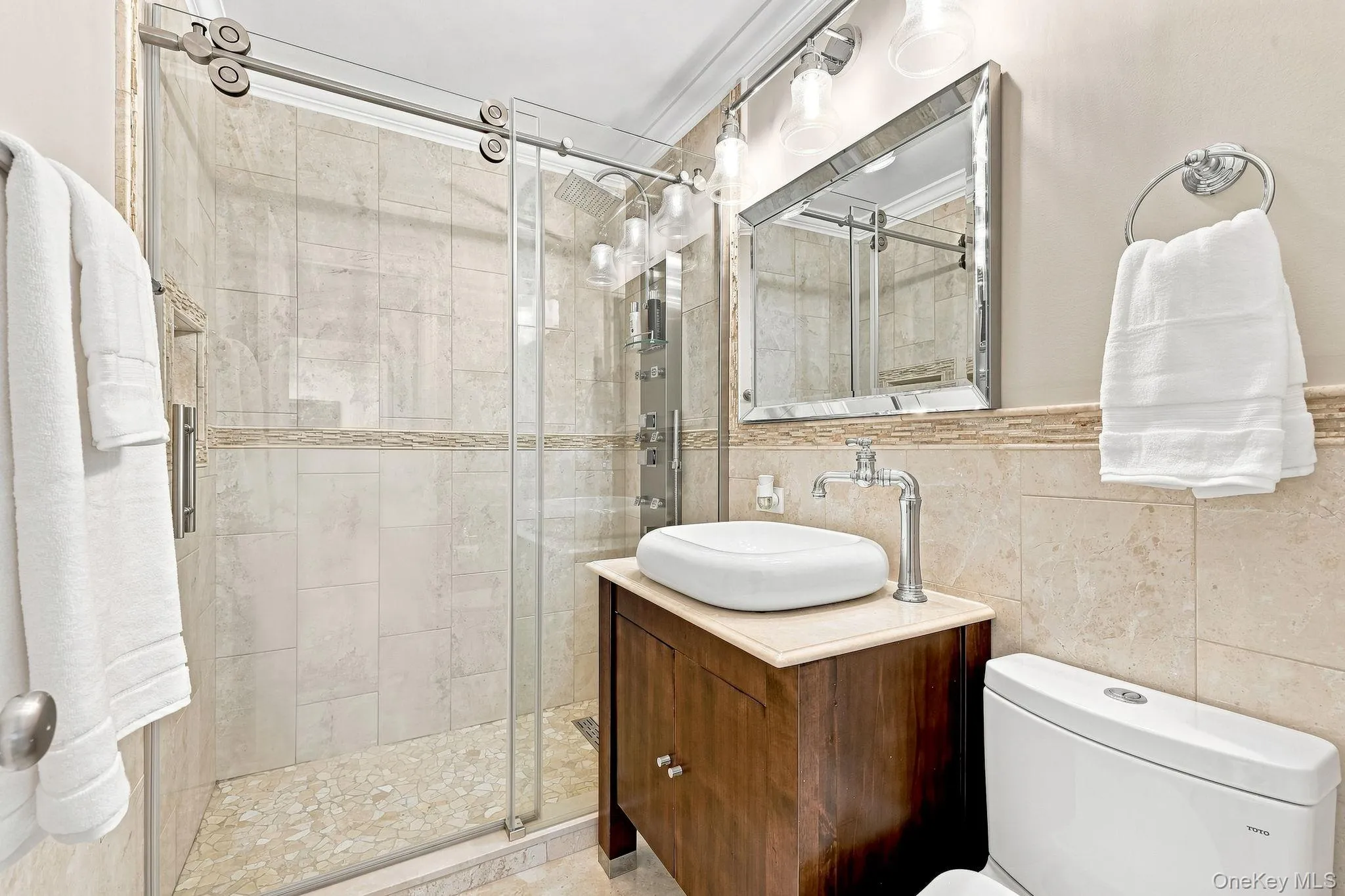 The hall bathroom with porcelain vessel sink that sits on the marble countertop has an Italian VIGO waterfall faucet, and the shower stall with body jet shower system has the sliding barn door entry The hall bathroom with porcelain vessel sink that sits on the marble countertop has an Italian VIGO waterfall faucet, and the shower stall with body jet shower system has the sliding barn door entry