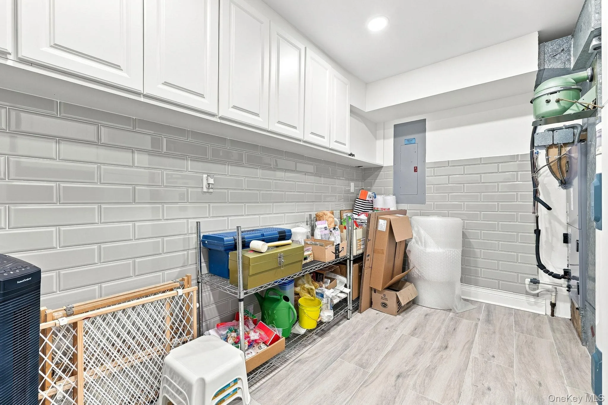 This separate walk-in storage/utility room in the townhouse has glass subway tile on the walls and white wall cabinetry after your trip home from Costco This separate walk-in storage/utility room in the townhouse has glass subway tile on the walls and white wall cabinetry after your trip home from Costco