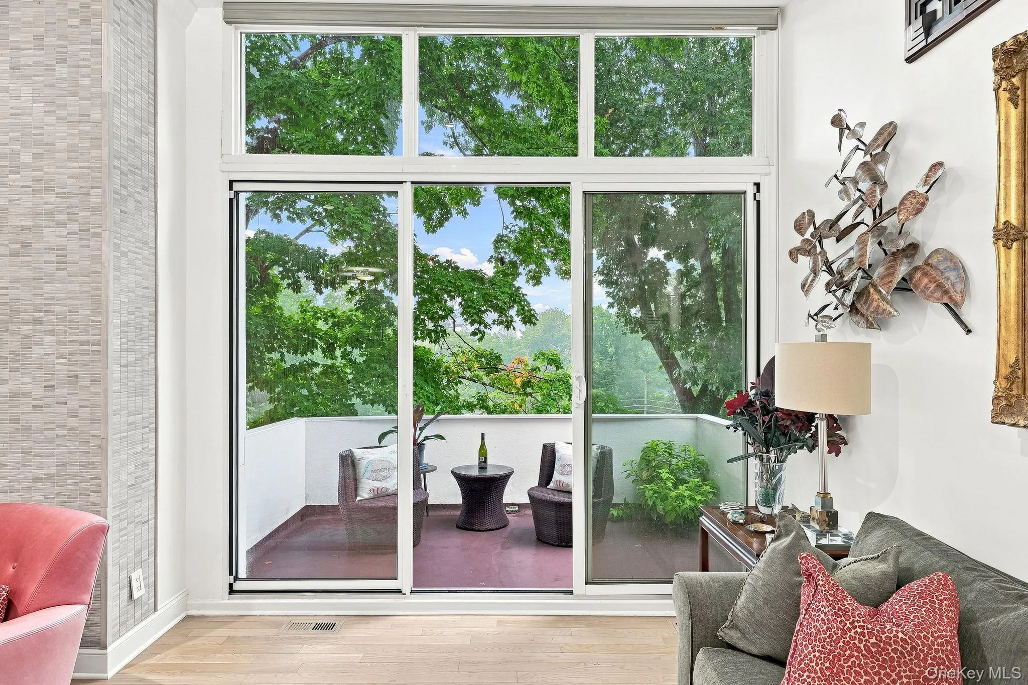 Full-height window wall with sliding glass doors and transom offers treetop views from the living room Full-height window wall with sliding glass doors and transom offers treetop views from the living room