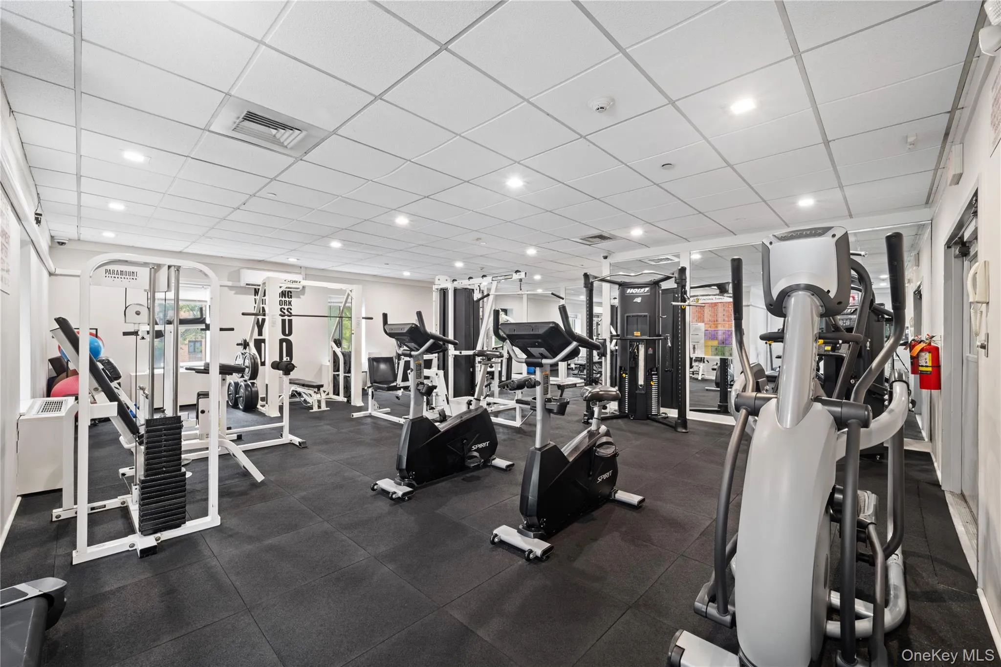 Fitness center featuring rubber mat flooring, recessed lighting, and mirrored wall accents Fitness center featuring rubber mat flooring, recessed lighting, and mirrored wall accents