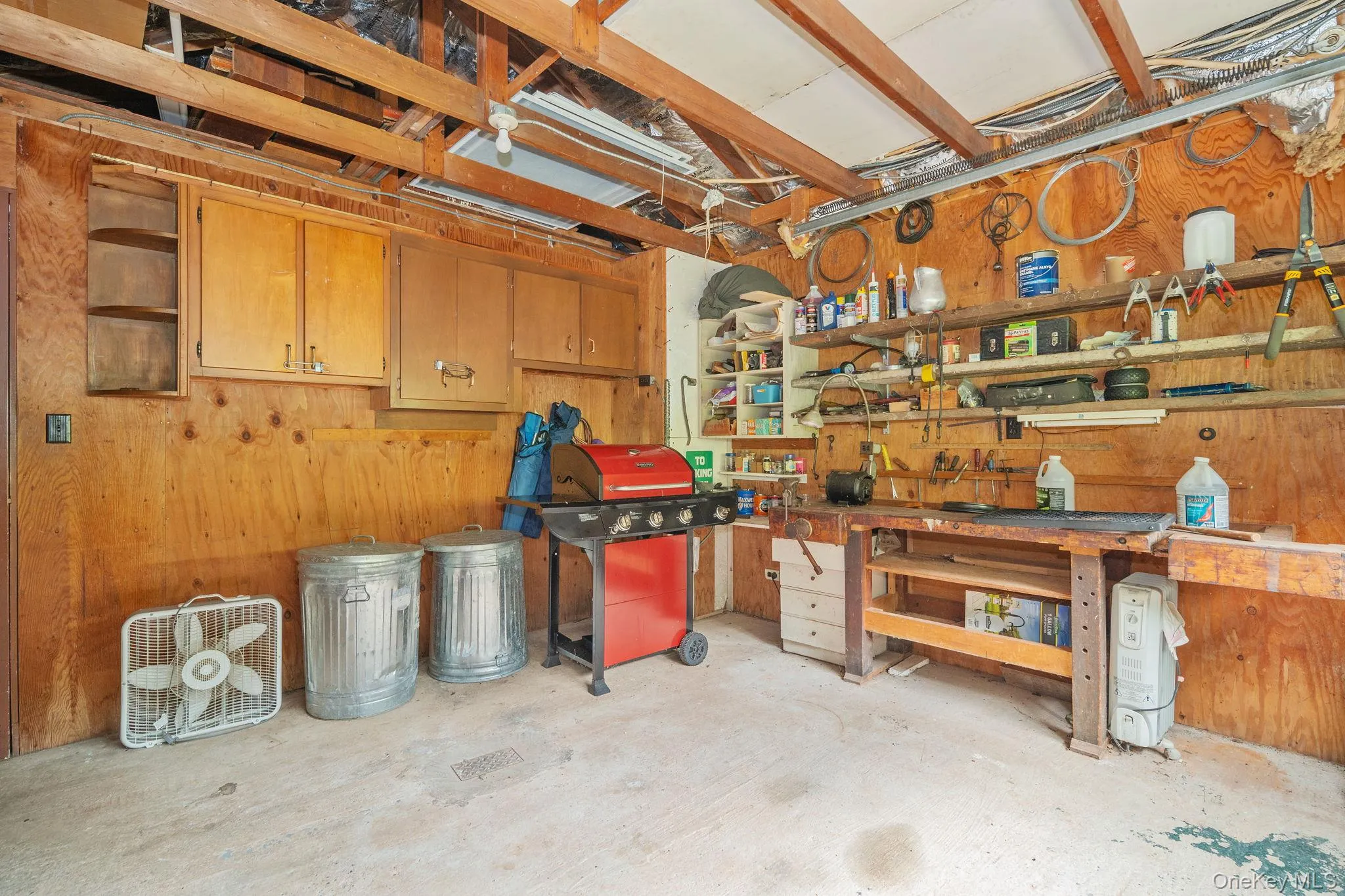 Exposed wood beam ceiling, wood paneling, built-in shelving, built-in cabinetry, concrete flooring Exposed wood beam ceiling, wood paneling, built-in shelving, built-in cabinetry, concrete flooring