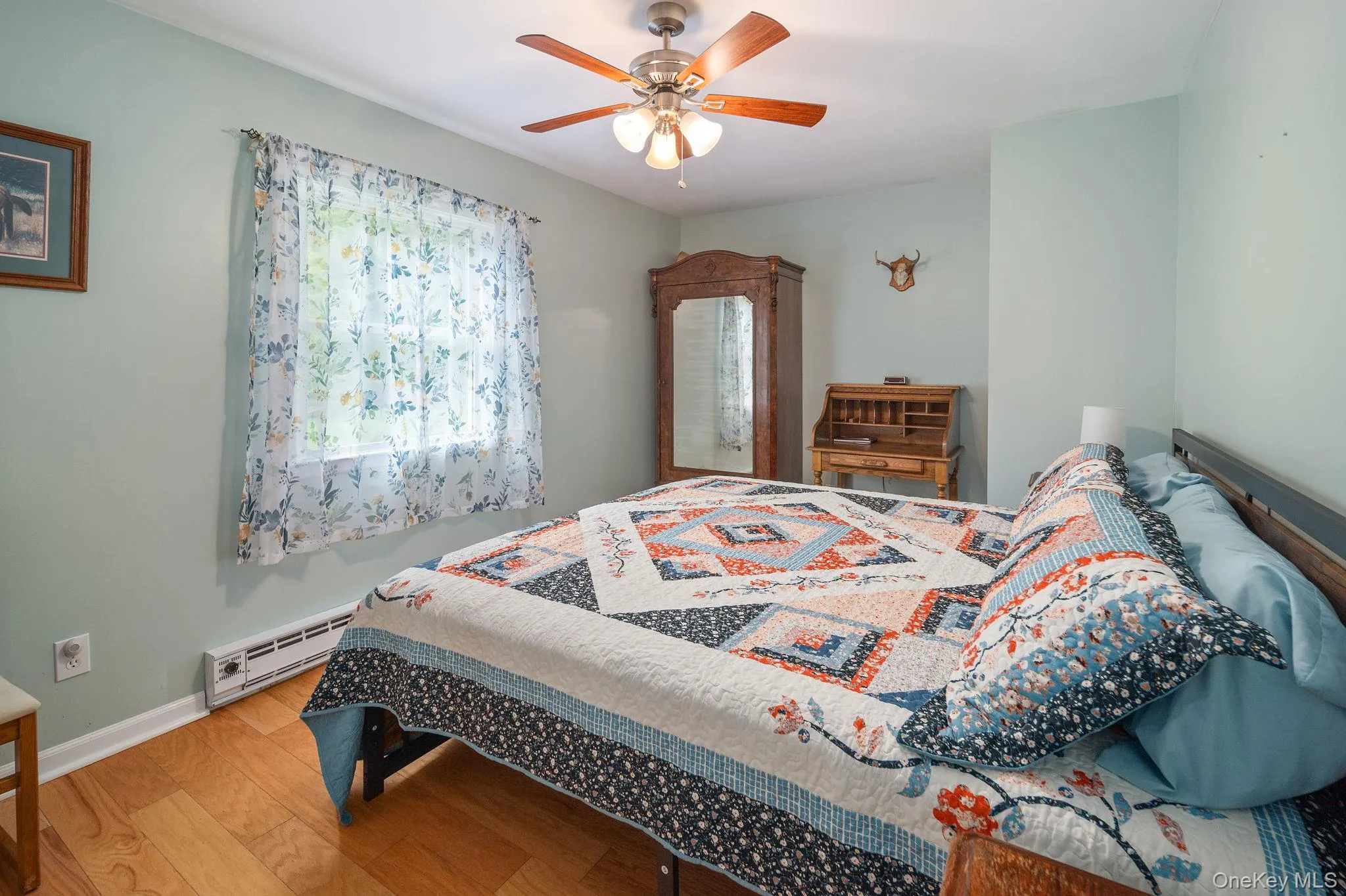 Wood-finish flooring, ceiling fan with integrated lighting, and a baseboard heater Wood-finish flooring, ceiling fan with integrated lighting, and a baseboard heater