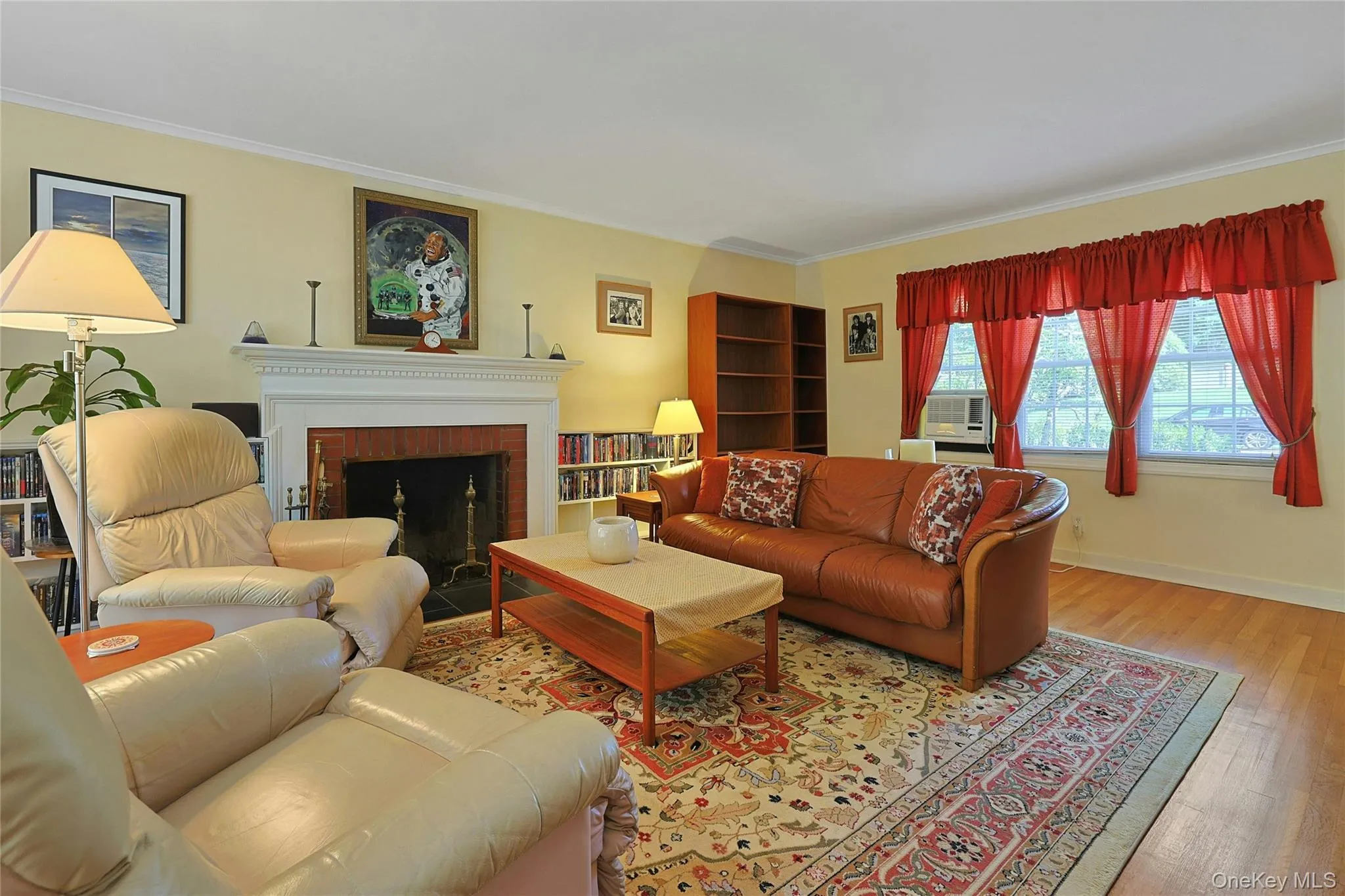 Spacious Living Room with hardwood flooring throughout, white crown molding, a wood burning fireplace, built-ins and multiple windows for lots of natural light. Spacious Living Room with hardwood flooring throughout, white crown molding, a wood burning fireplace, built-ins and multiple windows for lots of natural light.