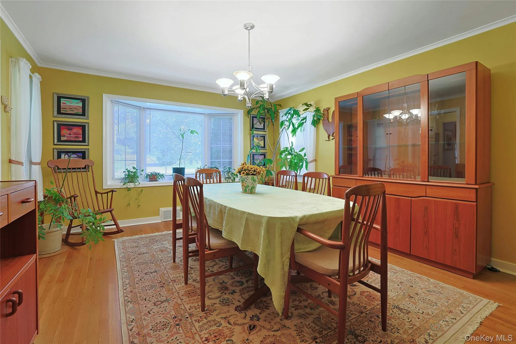 Formal Dining Room with hardwood flooring, crown molding, a bay window, and 2 additional windows for lots of natural light. Formal Dining Room with hardwood flooring, crown molding, a bay window, and 2 additional windows for lots of natural light.