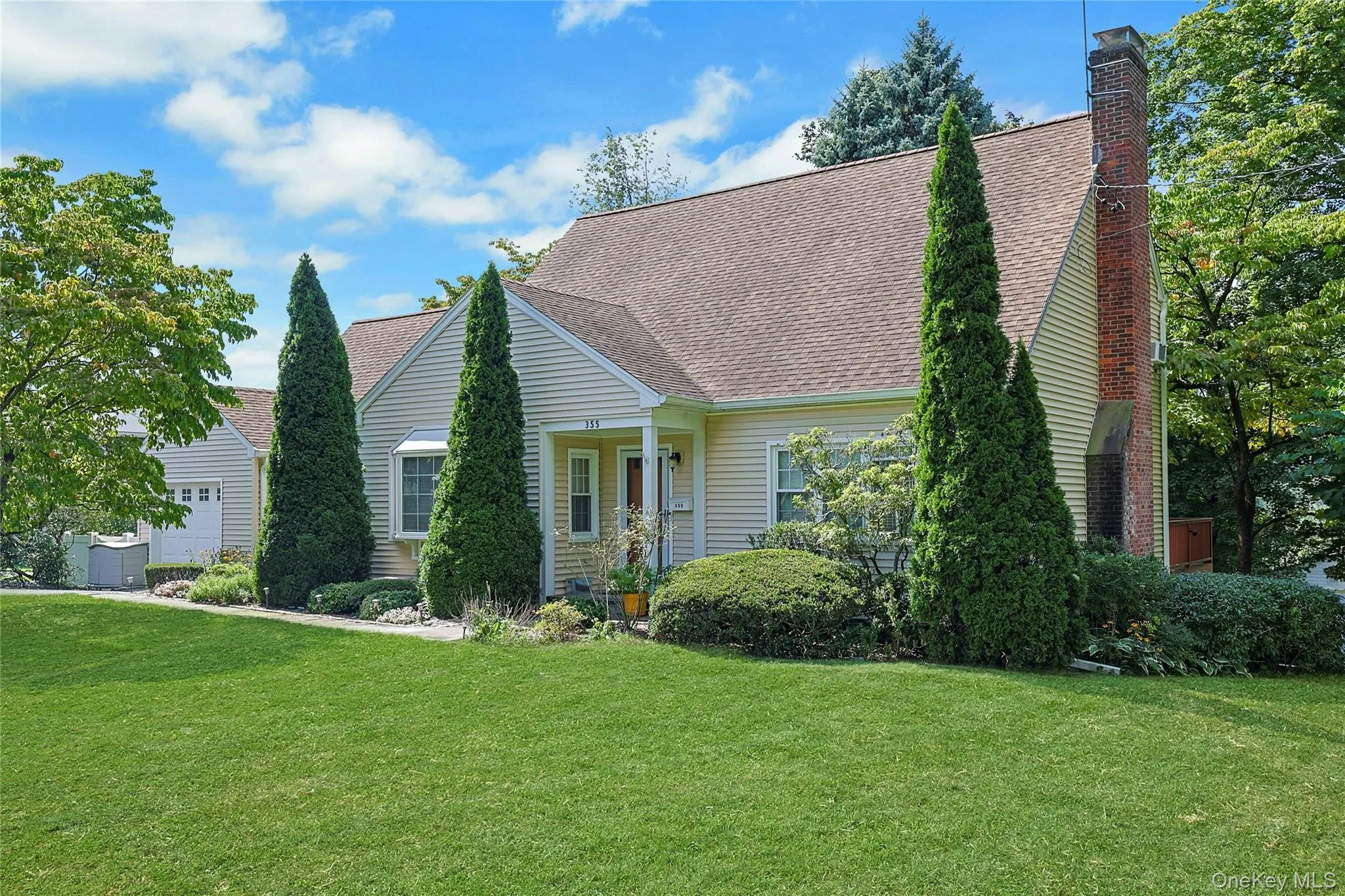 Gable Roofline Residence with Neutral Siding, and a Prominent Brick Chimney. Gable Roofline Residence with Neutral Siding, and a Prominent Brick Chimney.