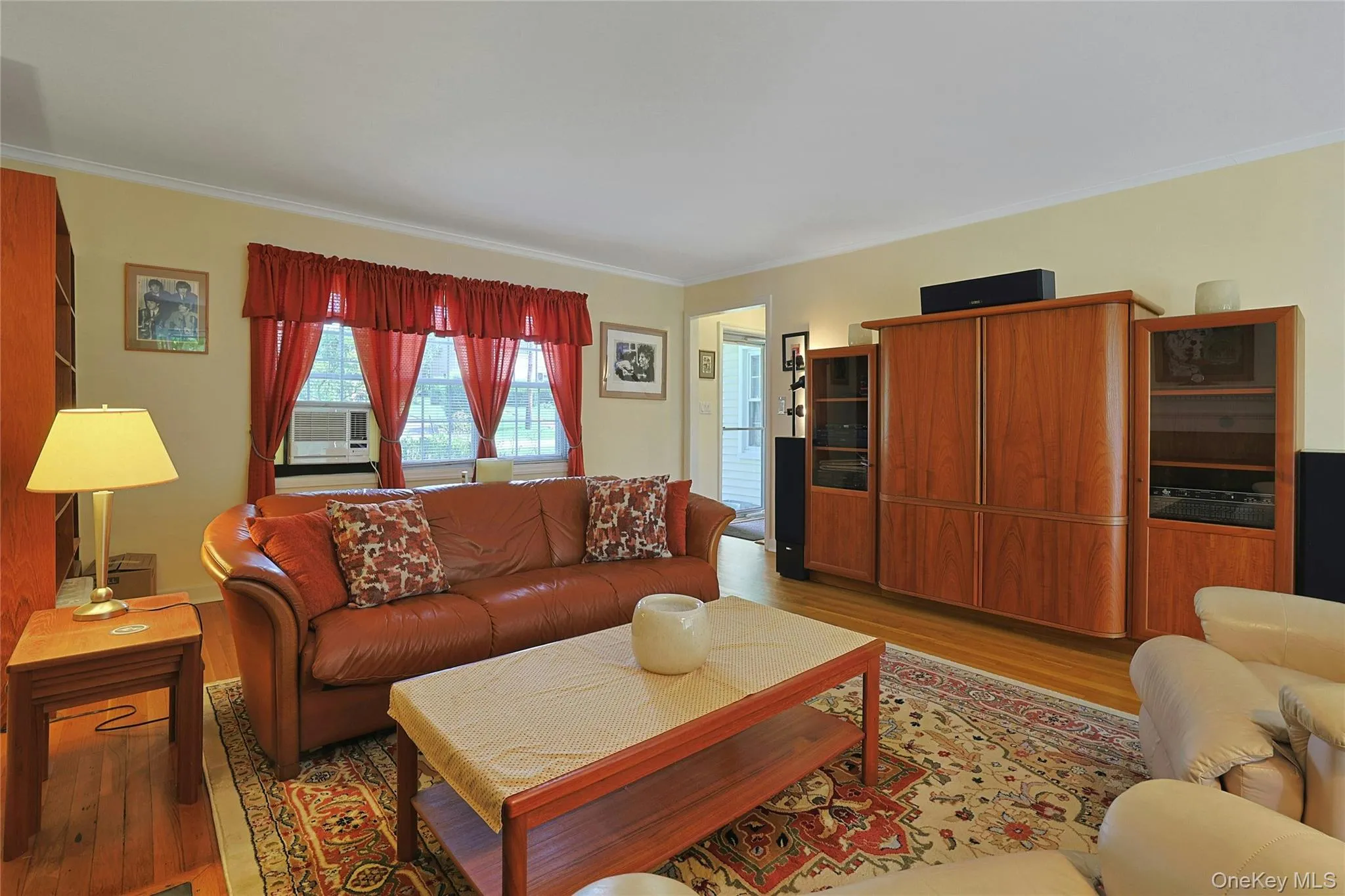 Another view of the Living Room showing warm-toned walls with crown molding and hardwood flooring. Another view of the Living Room showing warm-toned walls with crown molding and hardwood flooring.
