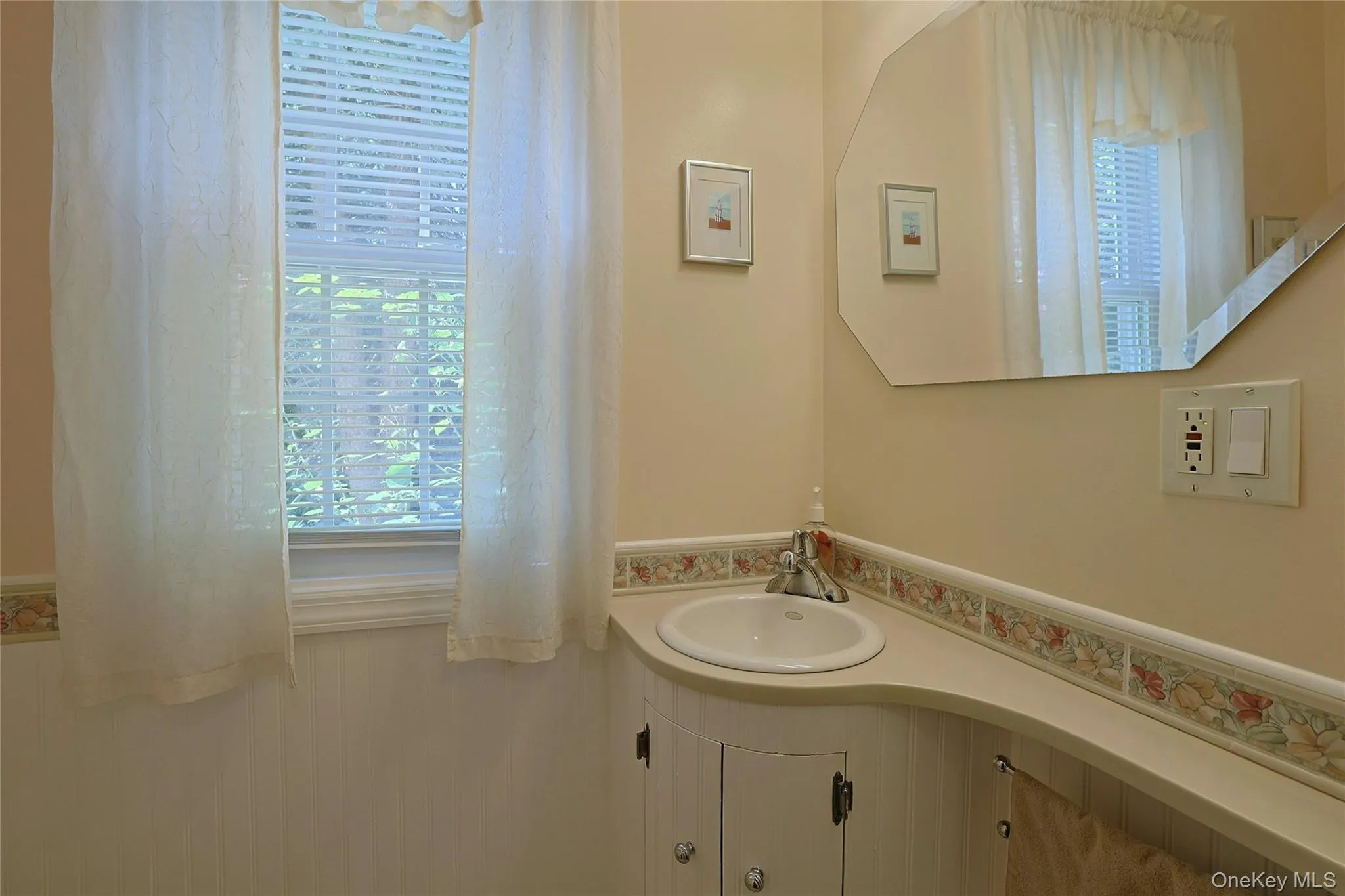 Powder Room with chrome-finish faucet, curved countertop, and built-in vanity cabinetry. Powder Room with chrome-finish faucet, curved countertop, and built-in vanity cabinetry.