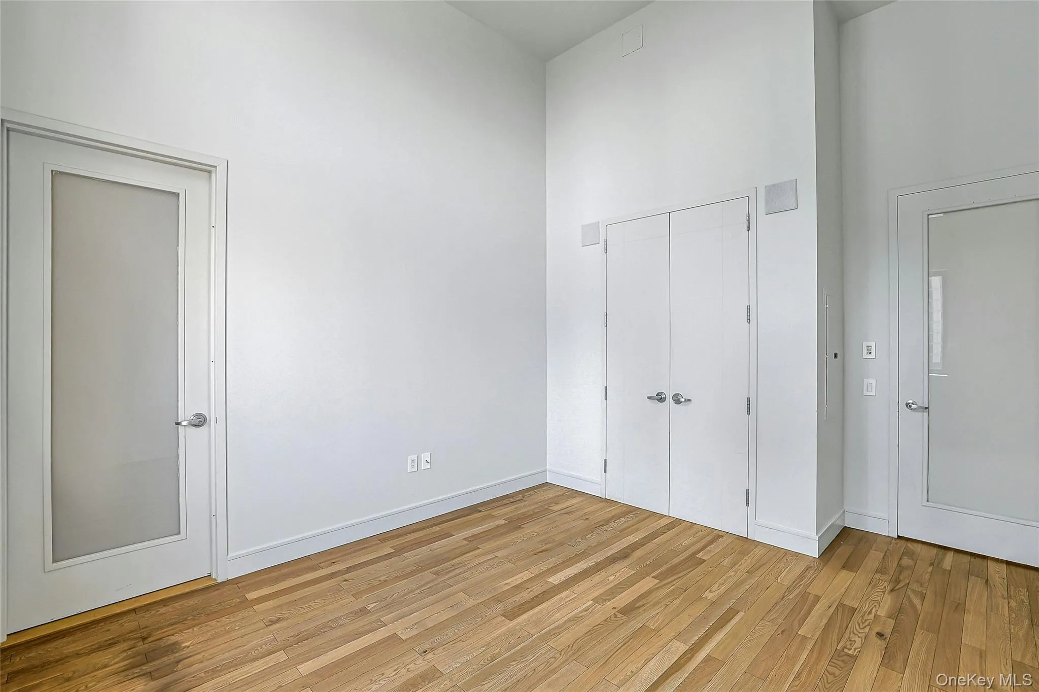 Flexible bedroom or office space featuring soaring ceilings, hardwood floors, and ample closet storage. Flexible bedroom or office space featuring soaring ceilings, hardwood floors, and ample closet storage.