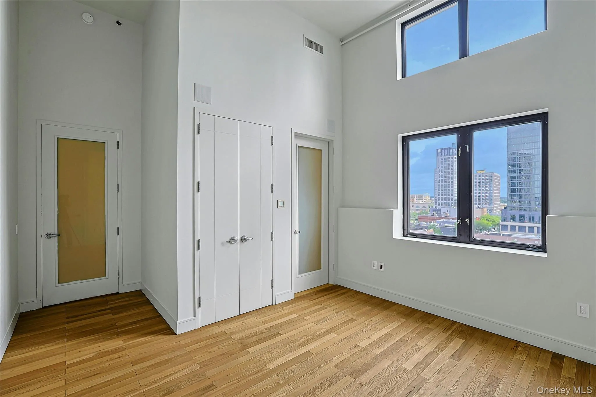 Bright and spacious bedroom featuring high ceilings, hardwood floors, and generous closet space. Bright and spacious bedroom featuring high ceilings, hardwood floors, and generous closet space.
