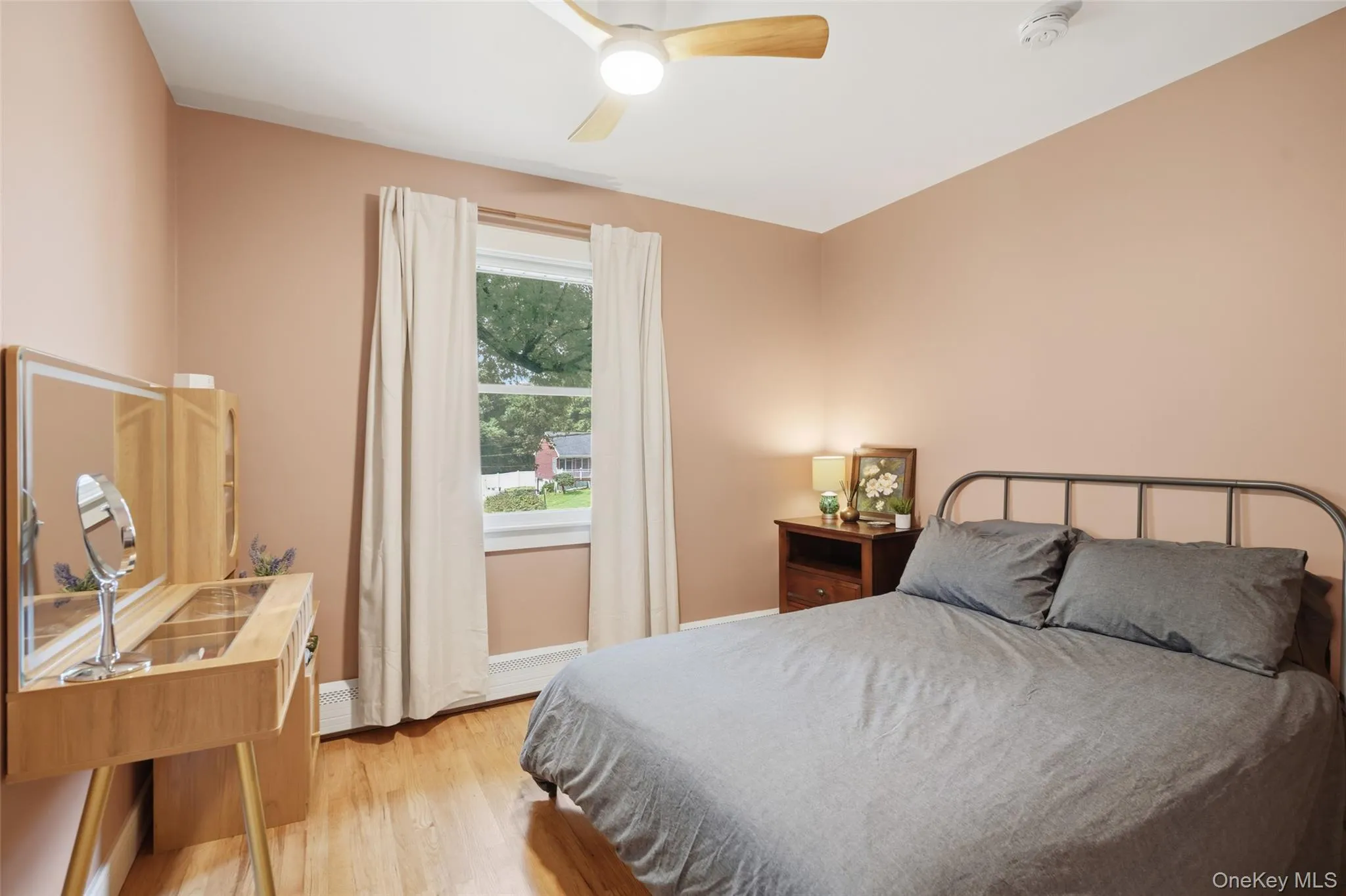 Wood-finish flooring, ceiling fan with integrated lighting, and a window with natural light Wood-finish flooring, ceiling fan with integrated lighting, and a window with natural light