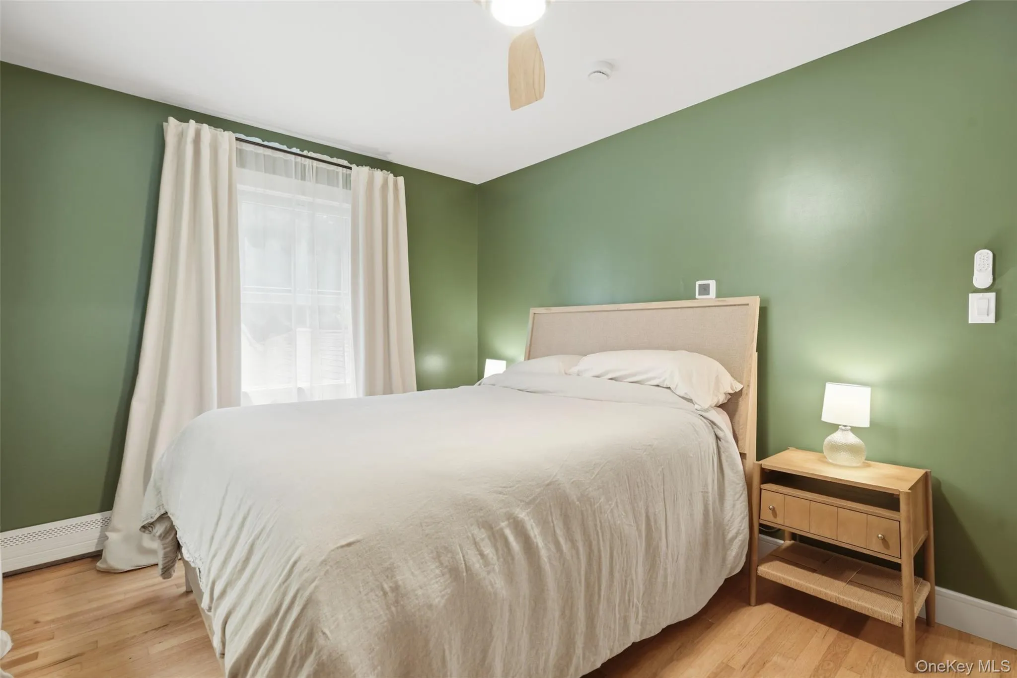 Hardwood flooring, ceiling fan, window with blinds, and a built-in radiator Hardwood flooring, ceiling fan, window with blinds, and a built-in radiator