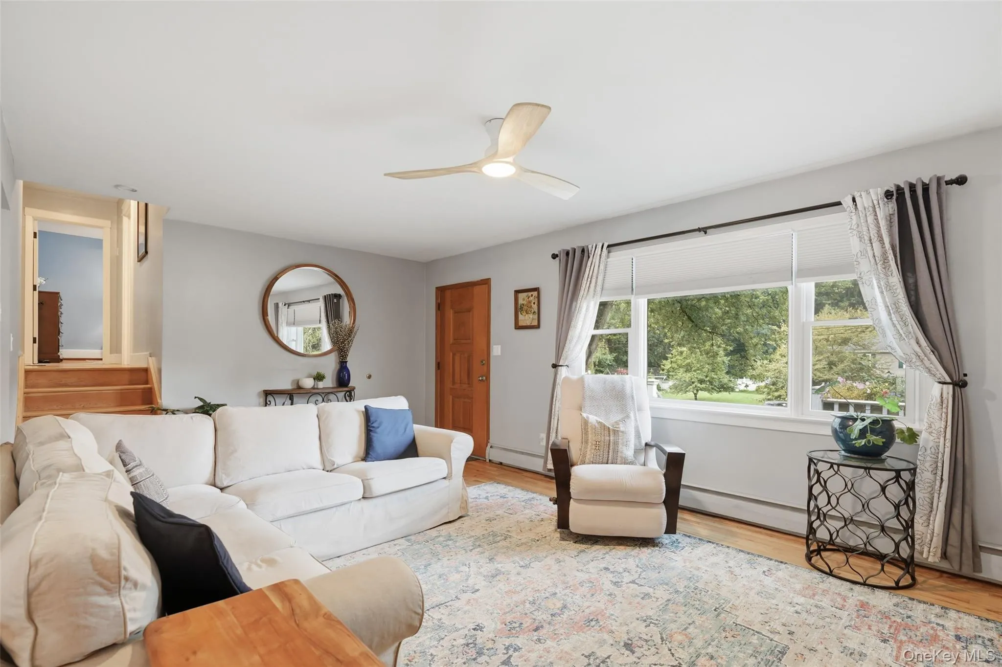 Hardwood flooring, multi-pane window, ceiling fan, natural wood door, and a built-in staircase Hardwood flooring, multi-pane window, ceiling fan, natural wood door, and a built-in staircase