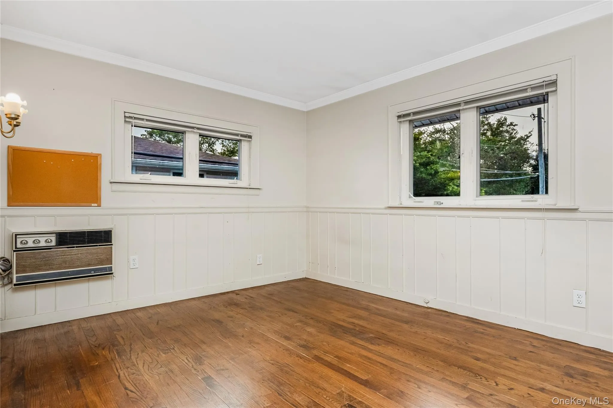 Wood-finish flooring with white wainscoting and crown molding Wood-finish flooring with white wainscoting and crown molding