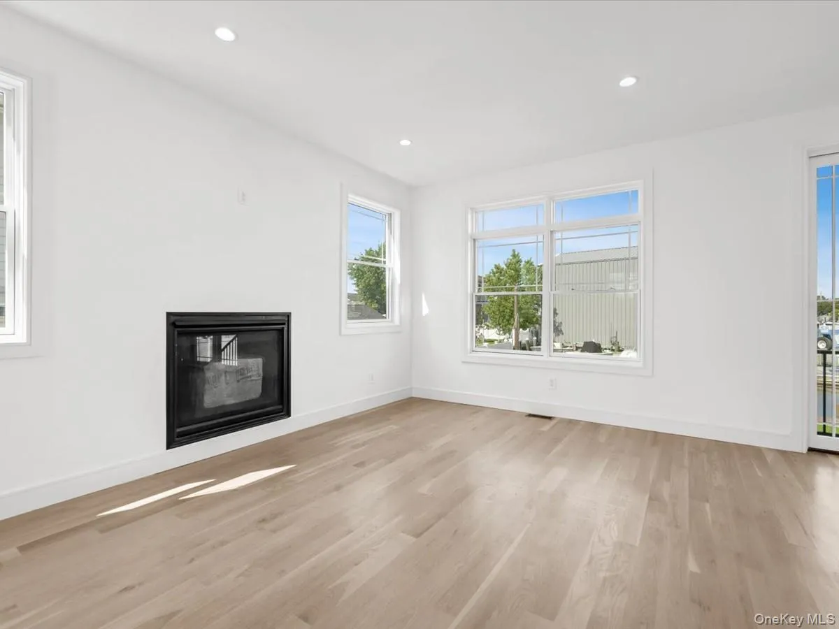 Recessed lighting, wood-finish flooring, multiple windows, and a built-in fireplace Recessed lighting, wood-finish flooring, multiple windows, and a built-in fireplace