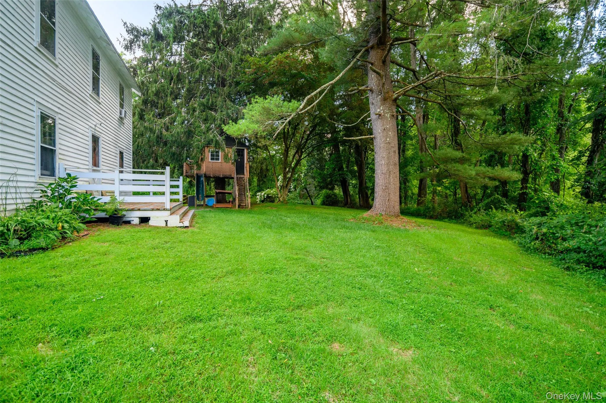 Back of home with back door leading to small deck. Back of home with back door leading to small deck.