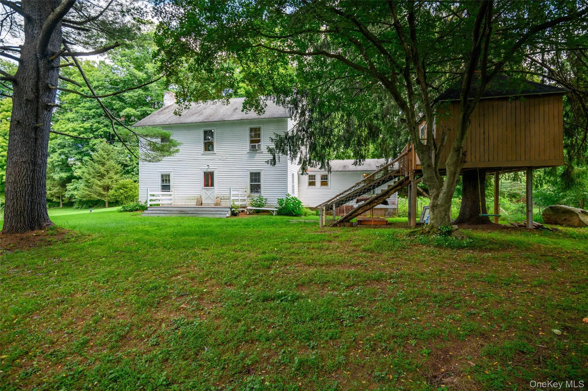 Back of the home with back deck & tree house Back of the home with back deck & tree house