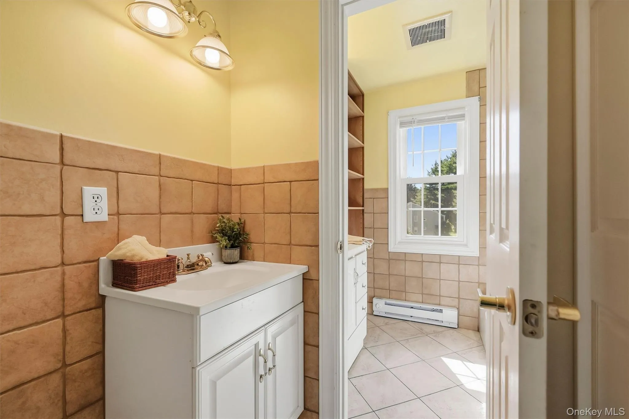 The bathroom is fully tiled with 2 individual sinks and vanities The bathroom is fully tiled with 2 individual sinks and vanities
