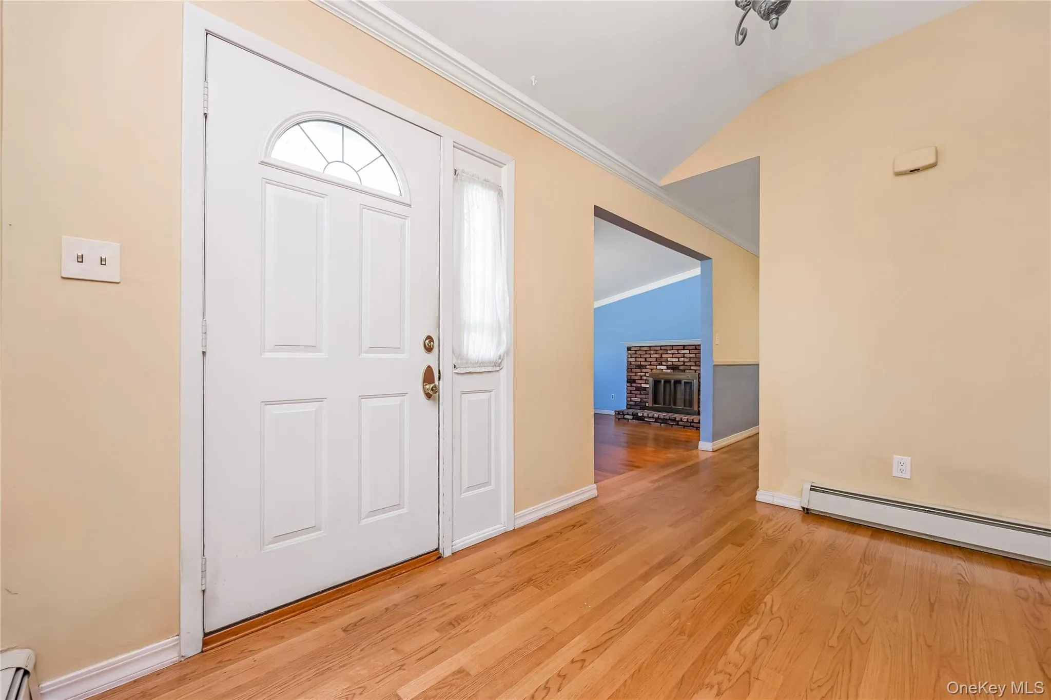 Large Foyer with hardwood flooring, paneled entry door with arched transom, sidelight Large Foyer with hardwood flooring, paneled entry door with arched transom, sidelight