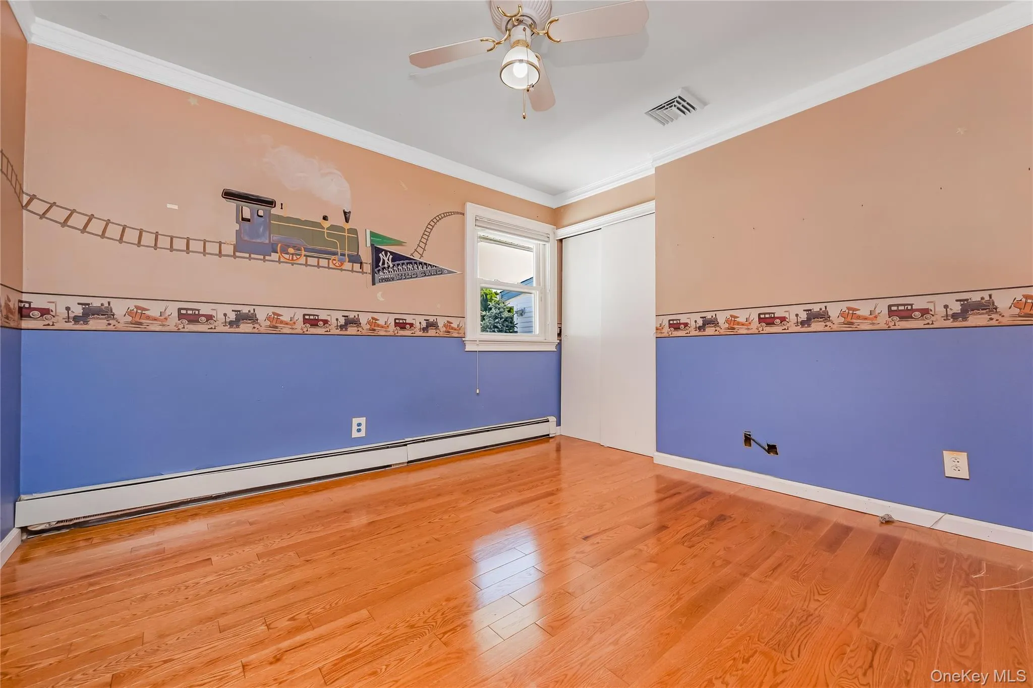 Bedroom 3 with wood-finish flooring, ceiling fan, white trim, a sizable closet and a window providing natural light Bedroom 3 with wood-finish flooring, ceiling fan, white trim, a sizable closet and a window providing natural light