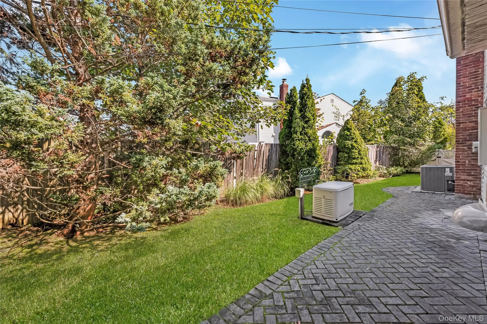 Side yard with mature trees, pavers, compressor and generator. Grass virtually enhanced Side yard with mature trees, pavers, compressor and generator. Grass virtually enhanced