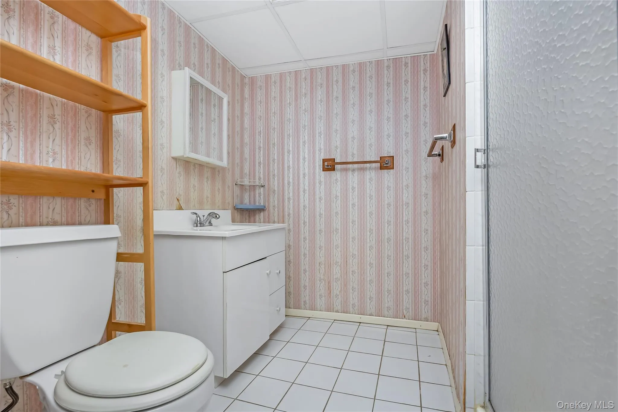 3rd bathroom with white tile flooring and a built-in vanity with a basin sink and a stall shower in the basement 3rd bathroom with white tile flooring and a built-in vanity with a basin sink and a stall shower in the basement