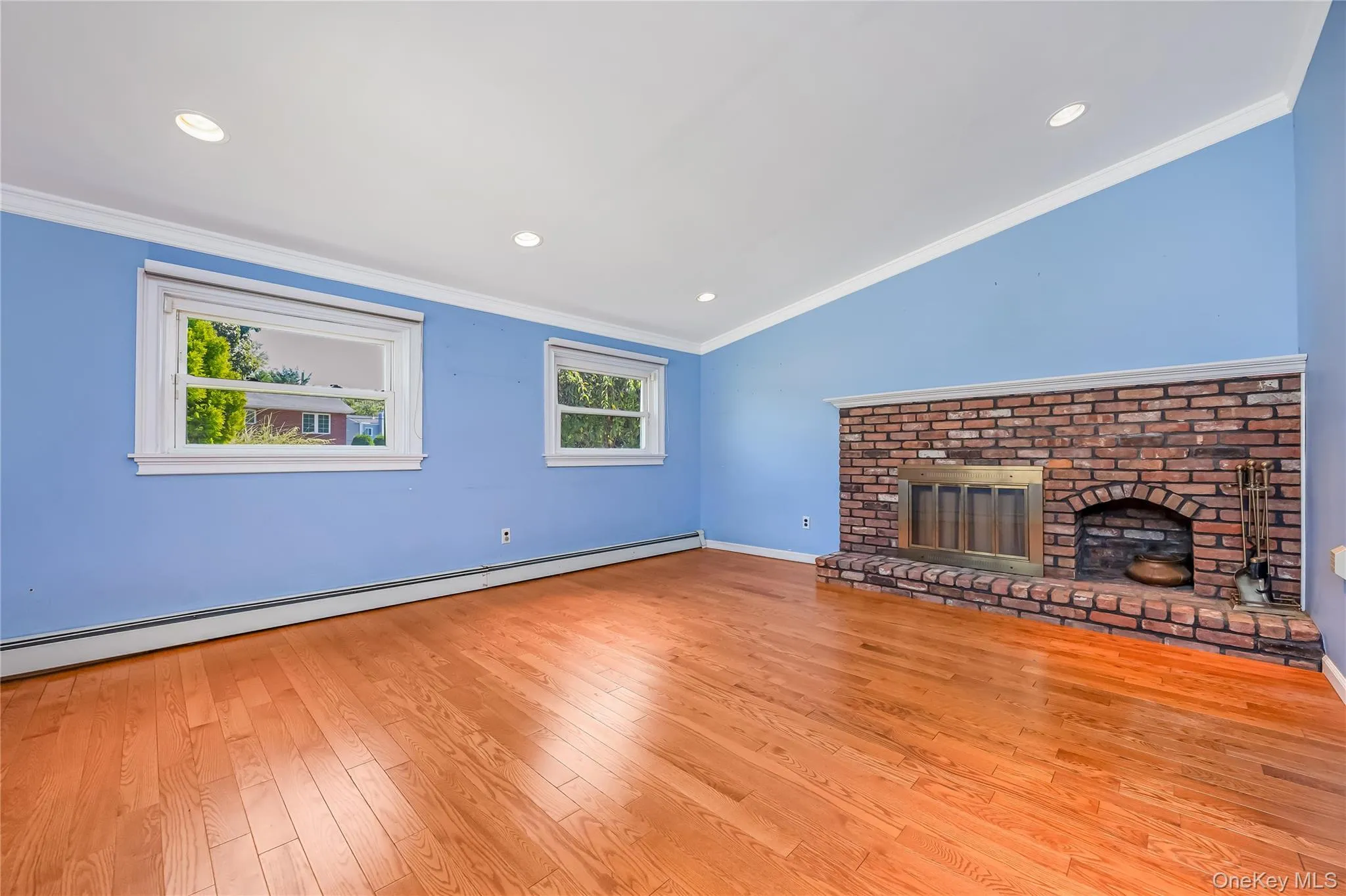 Sunken Den with hardwood flooring and a brick fireplace with a hearth Sunken Den with hardwood flooring and a brick fireplace with a hearth