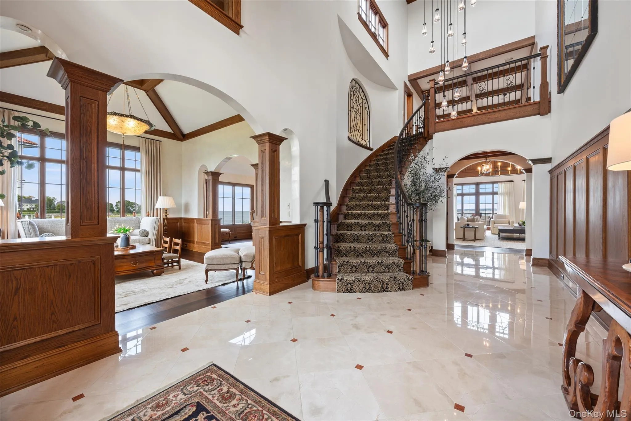 Entry hall with living room and family room access and grand stairway to second level. Entry hall with living room and family room access and grand stairway to second level.