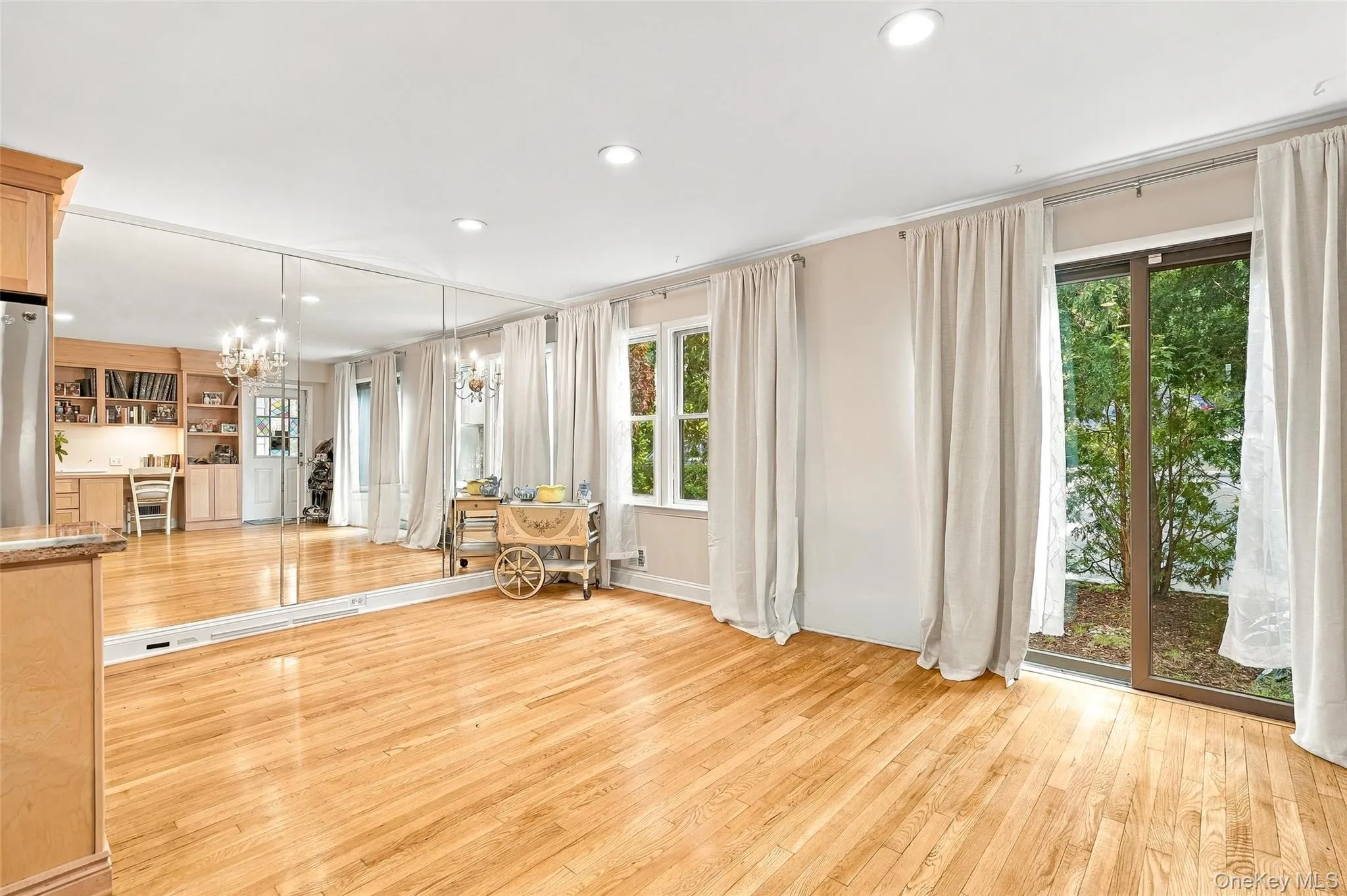 The mirrored wall makes the living space feel even larger than it is and the glass doors bring the outdoors in. The mirrored wall makes the living space feel even larger than it is and the glass doors bring the outdoors in.