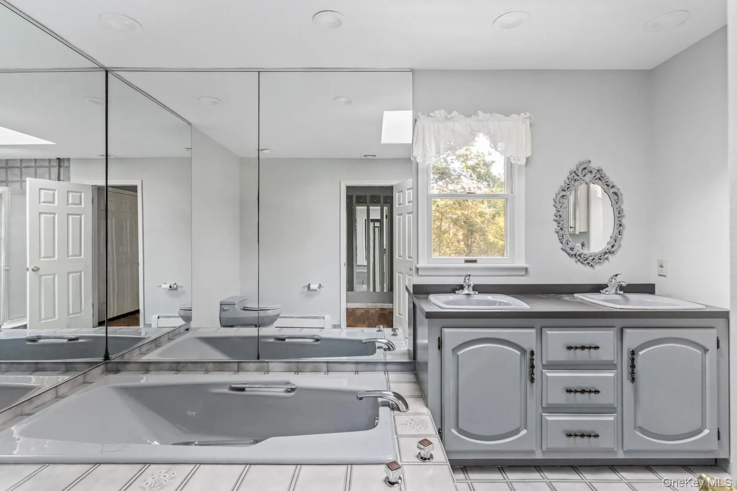 Primary Bathroom featuring double vanity, recessed lighting, and a bath Primary Bathroom featuring double vanity, recessed lighting, and a bath