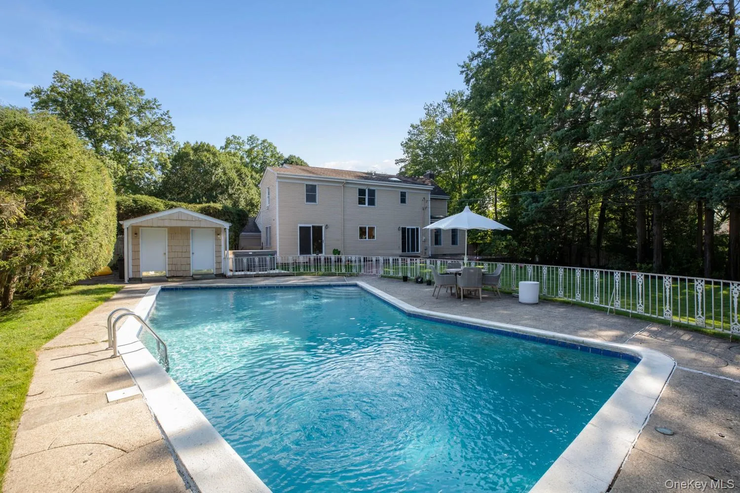 View of pool with view of wooded area, a patio area, an outbuilding, and outdoor dining space View of pool with view of wooded area, a patio area, an outbuilding, and outdoor dining space