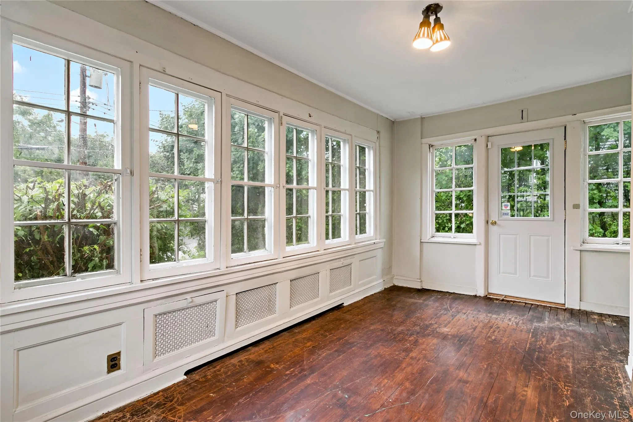 Sunroom with walls of windows and door to backyard Sunroom with walls of windows and door to backyard