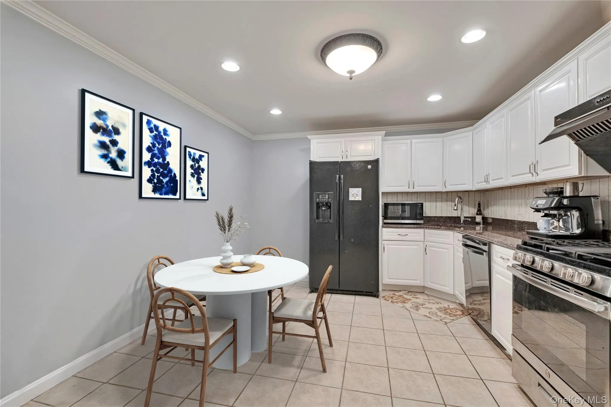 Kitchen featuring appliances with stainless steel finishes, decorative backsplash, crown molding, white cabinetry, and recessed lighting Kitchen featuring appliances with stainless steel finishes, decorative backsplash, crown molding, white cabinetry, and recessed lighting