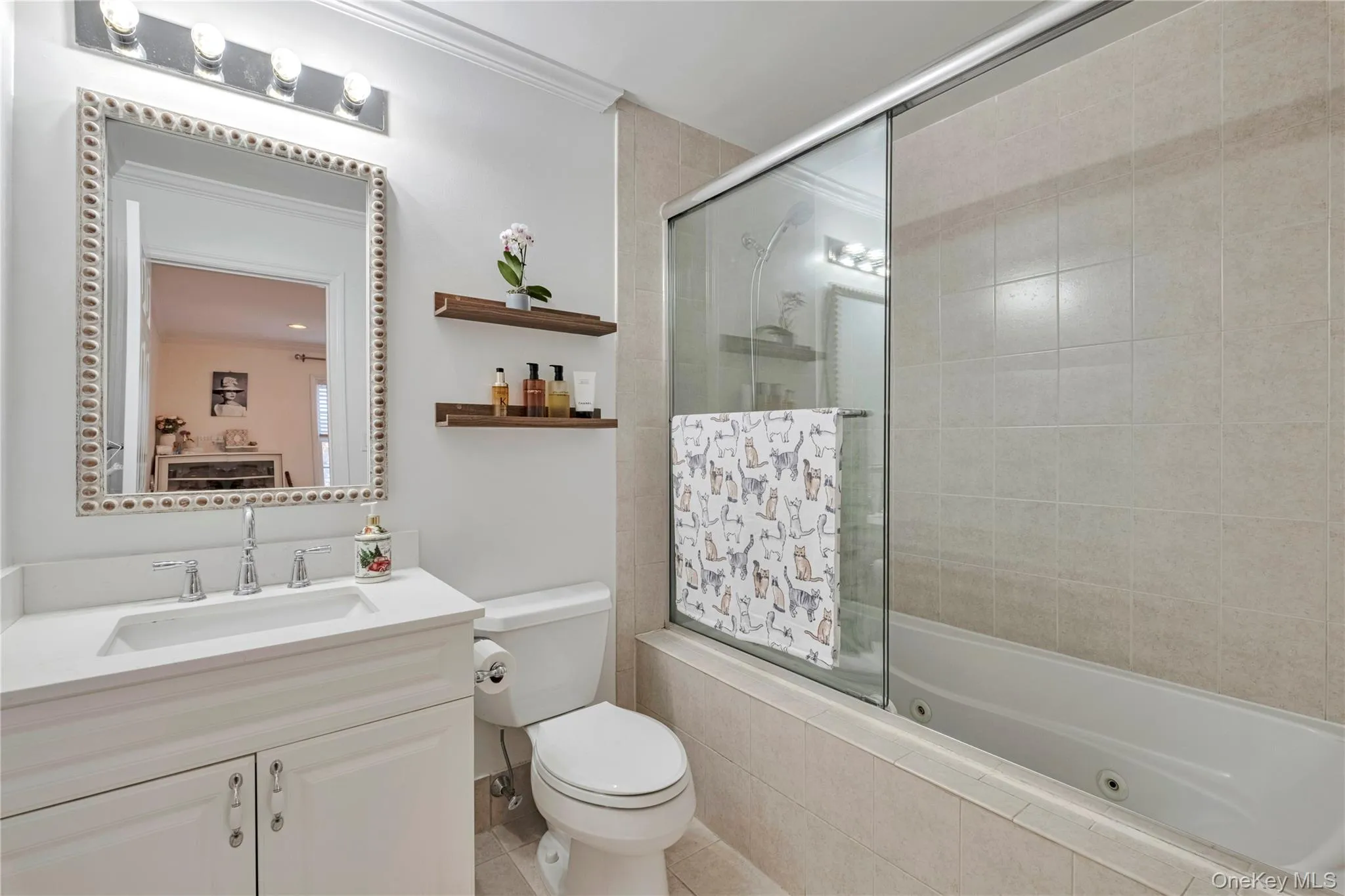 Bathroom featuring a combined bath / shower with jetted tub, vanity, and ornamental molding Bathroom featuring a combined bath / shower with jetted tub, vanity, and ornamental molding