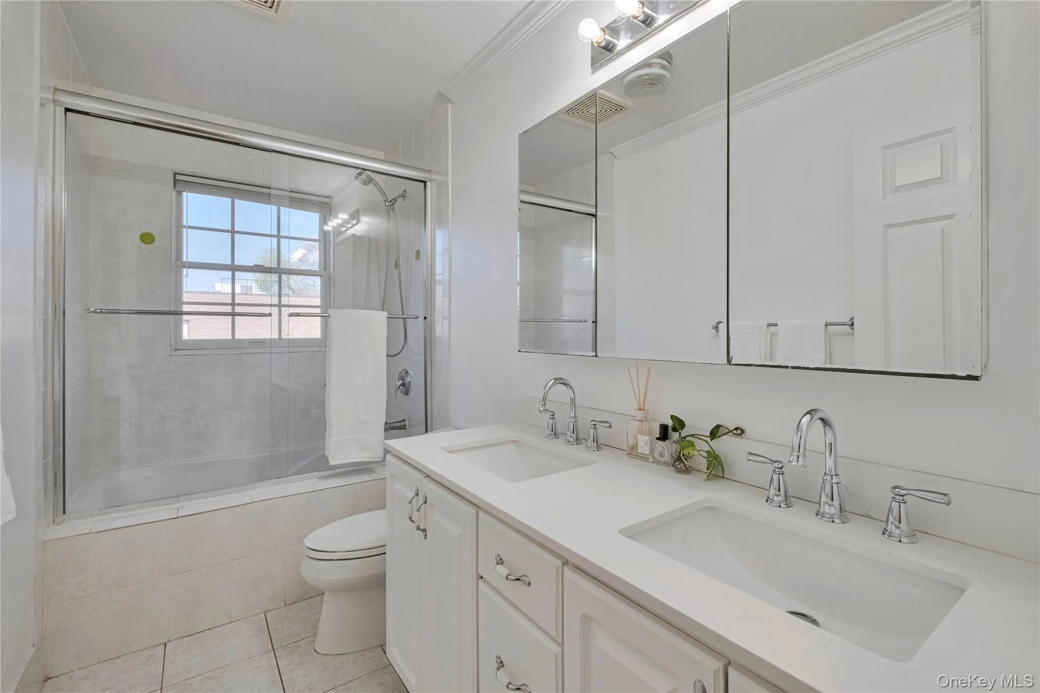 Bathroom with tiled shower / bath, tile patterned flooring, and double vanity Bathroom with tiled shower / bath, tile patterned flooring, and double vanity