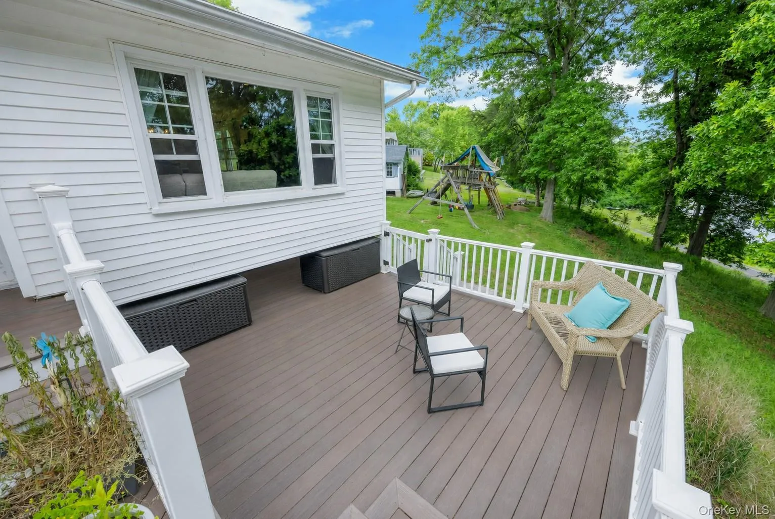 Spacious outdoor deck with composite wood-finish flooring and white railings Spacious outdoor deck with composite wood-finish flooring and white railings
