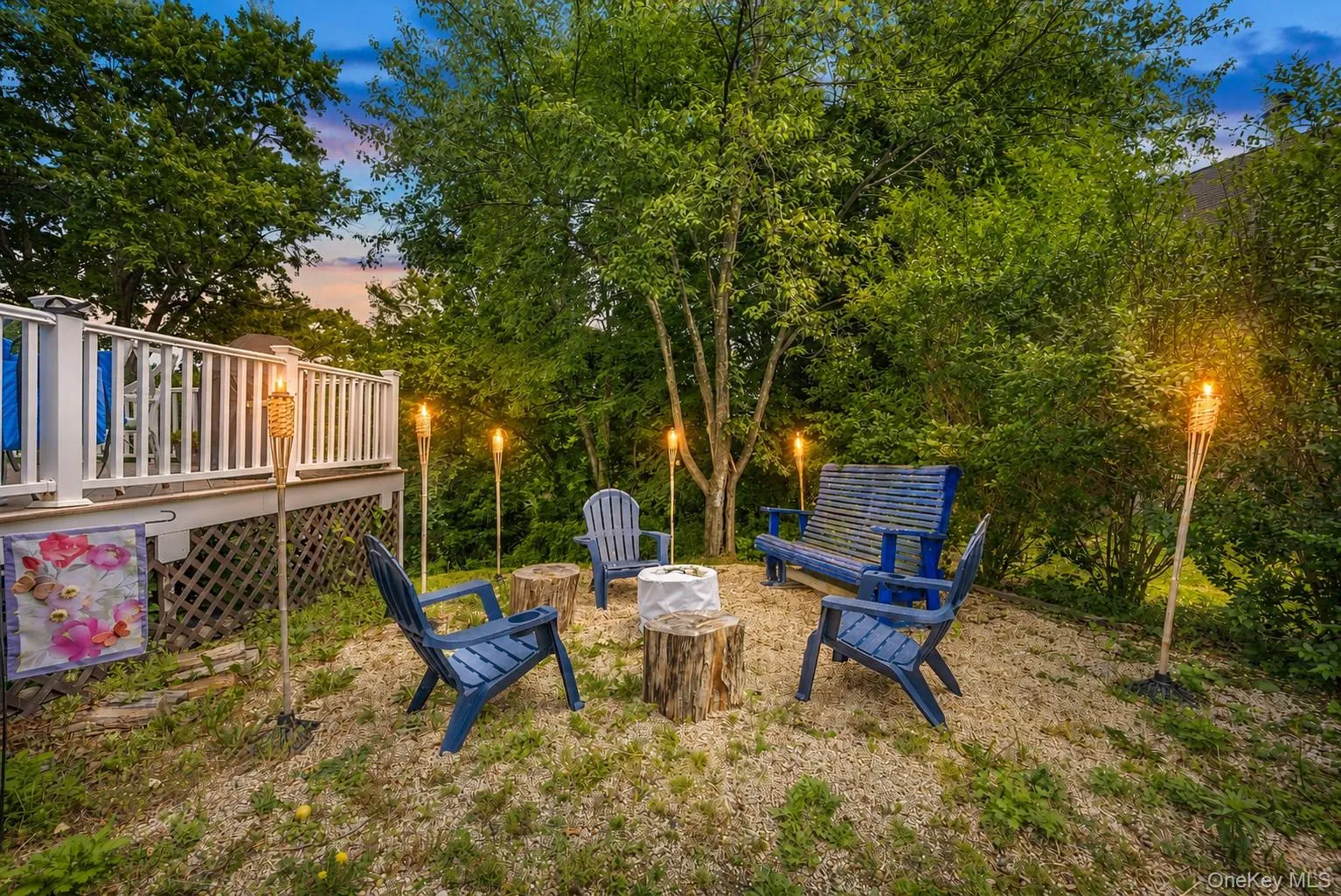Dedicated outdoor seating area featuring a gravel ground cover and surrounding mature trees Dedicated outdoor seating area featuring a gravel ground cover and surrounding mature trees