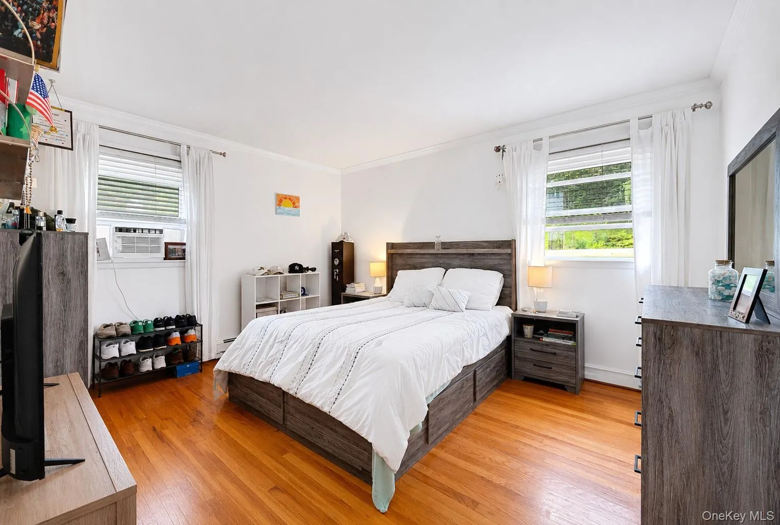 Hardwood flooring extending throughout, white walls, and bright windows with white blinds Hardwood flooring extending throughout, white walls, and bright windows with white blinds