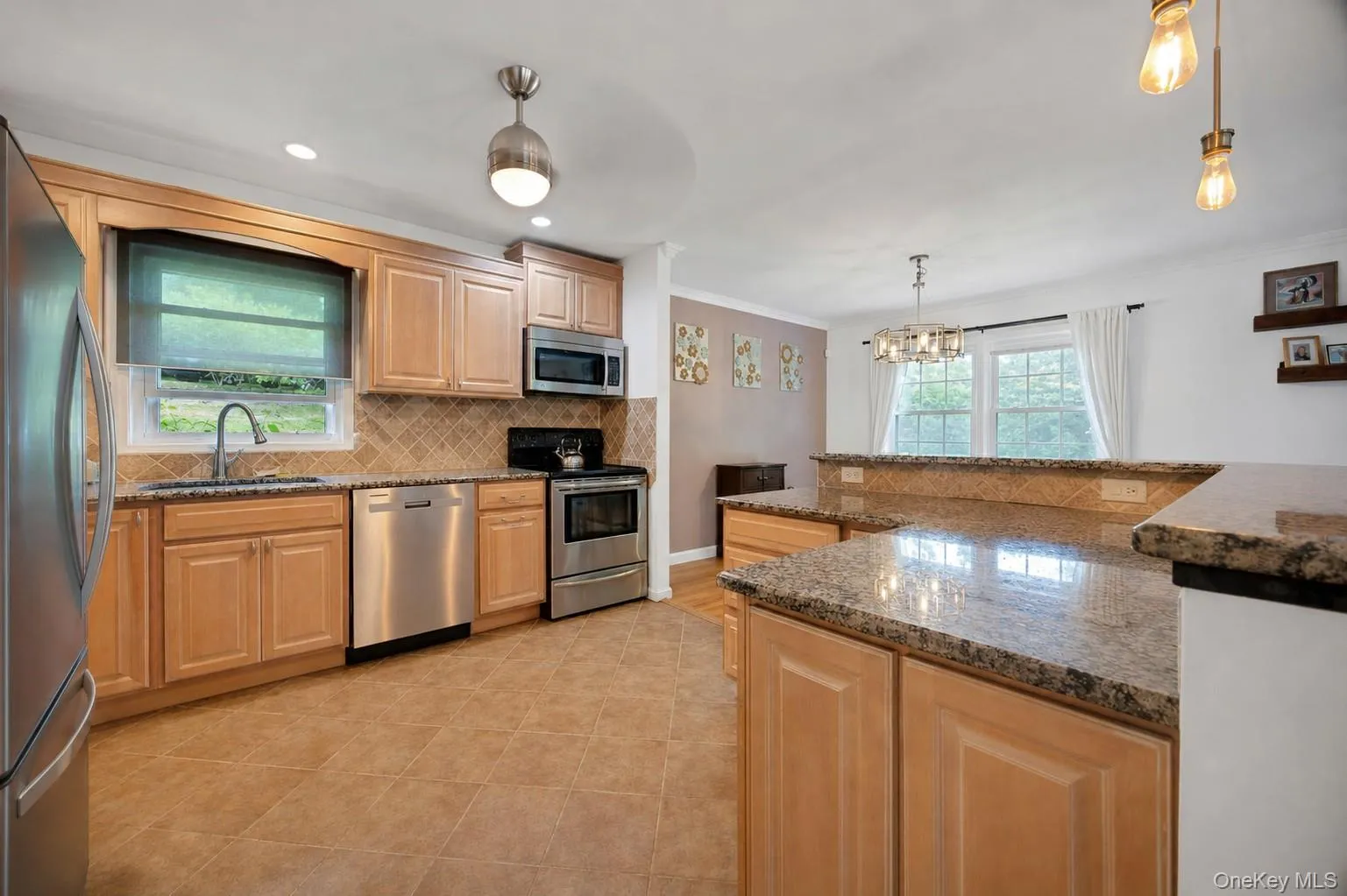 Kitchen featuring wood cabinetry, stainless steel appliances, granite countertops, and tiled flooring Kitchen featuring wood cabinetry, stainless steel appliances, granite countertops, and tiled flooring