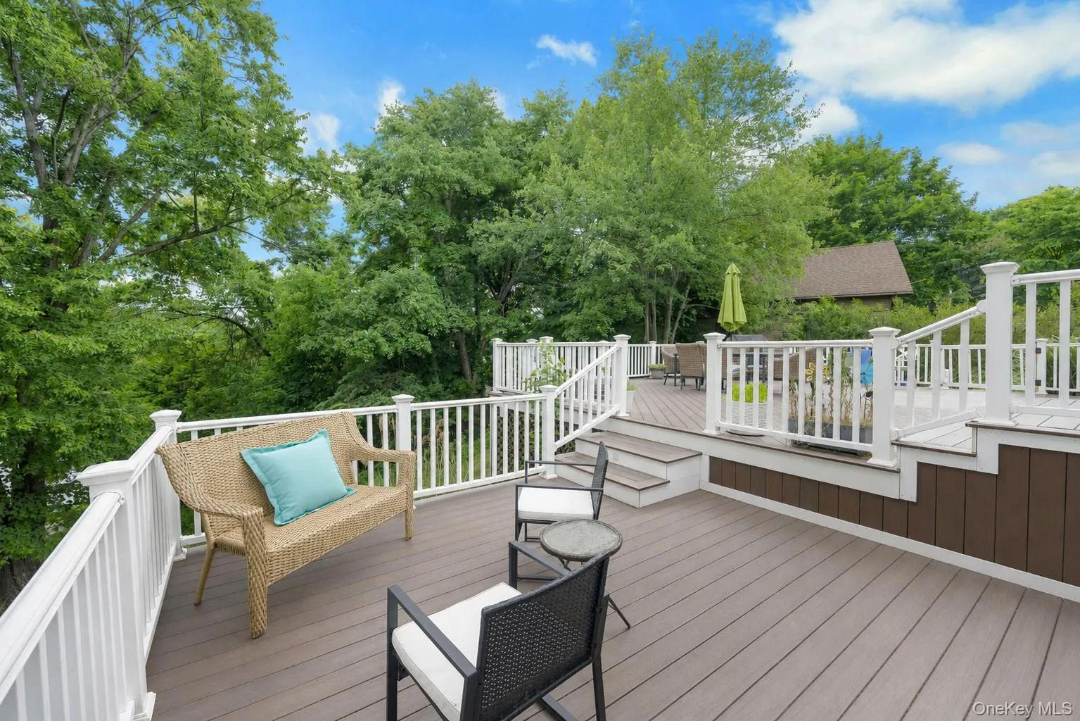 Multi-level outdoor deck featuring composite decking, white railings, and integrated steps Multi-level outdoor deck featuring composite decking, white railings, and integrated steps