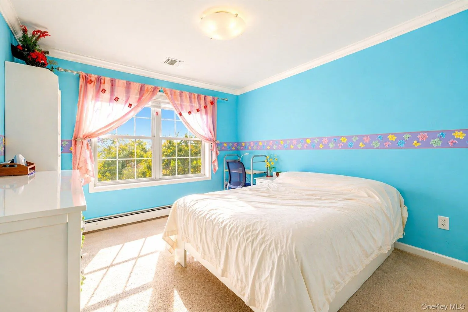 Carpeted room featuring a large window with white trim, crown molding, and a built-in light fixture Carpeted room featuring a large window with white trim, crown molding, and a built-in light fixture