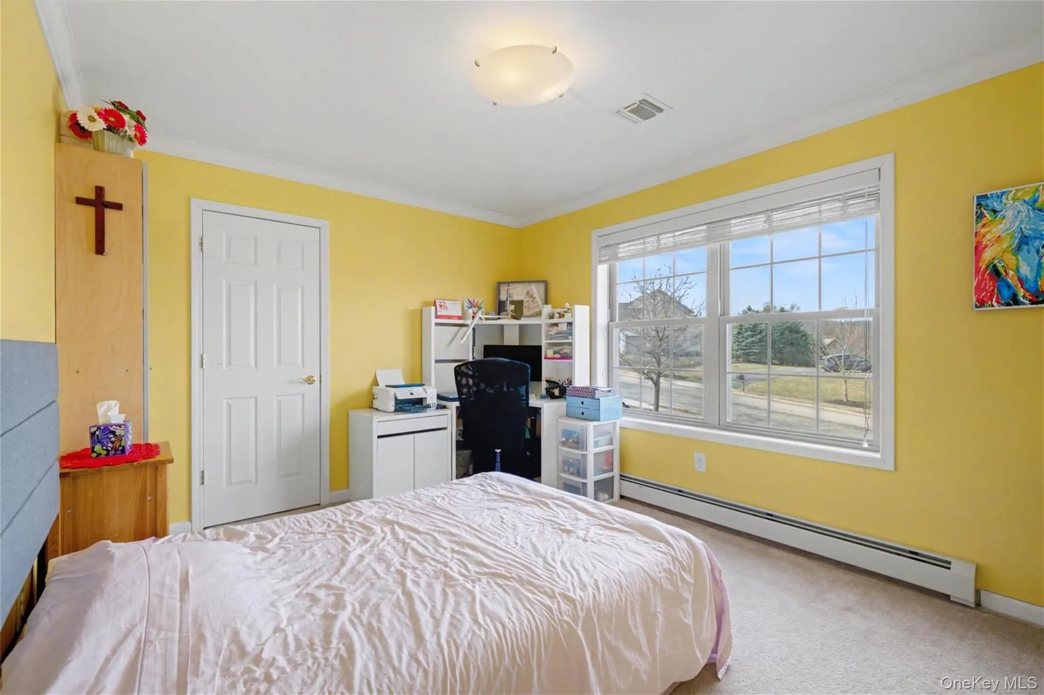 Room featuring a large multi-pane window, wall-to-wall carpeting, and baseboard heating Room featuring a large multi-pane window, wall-to-wall carpeting, and baseboard heating