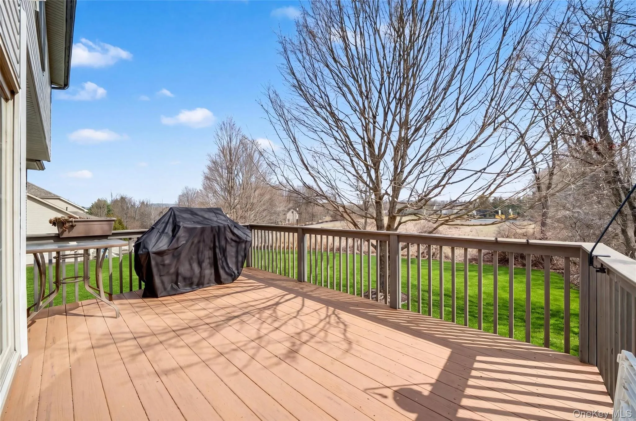 Spacious outdoor deck featuring wood-finish flooring and a wood railing Spacious outdoor deck featuring wood-finish flooring and a wood railing