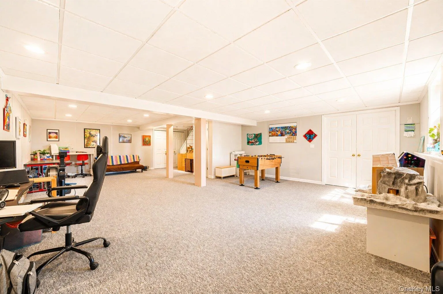 Spacious lower level featuring light gray carpeting, recessed lighting, and a drop ceiling Spacious lower level featuring light gray carpeting, recessed lighting, and a drop ceiling