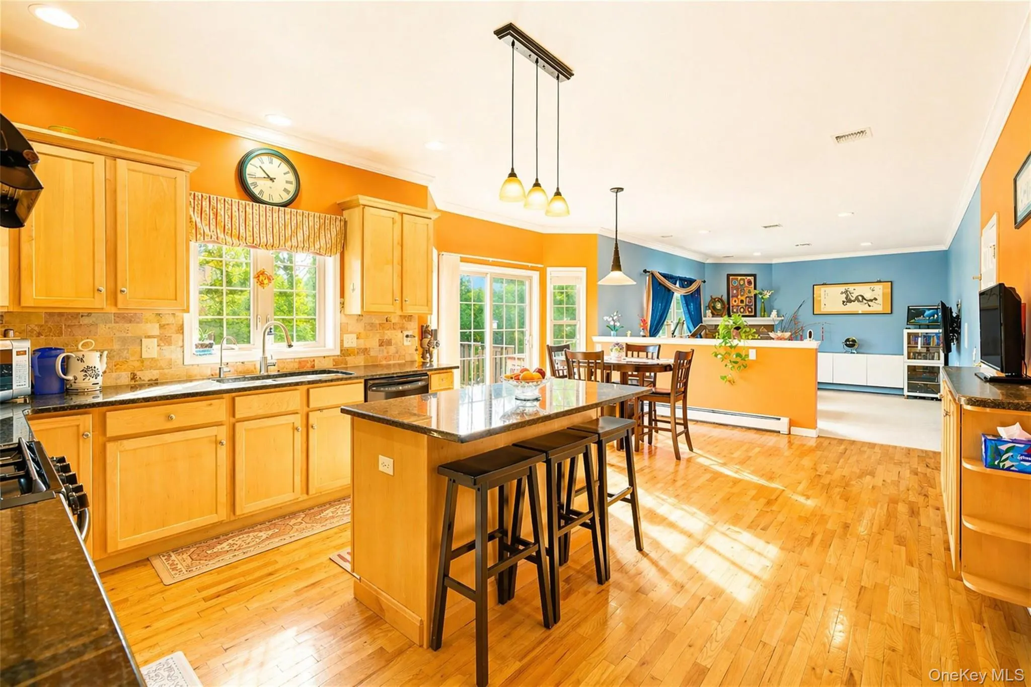 Kitchen featuring light wood cabinetry and wood-finish flooring Kitchen featuring light wood cabinetry and wood-finish flooring