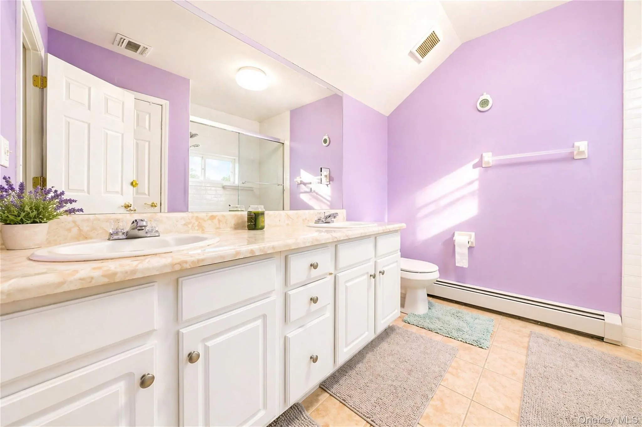 Double vanity with integrated sinks and a stone-finish countertop Double vanity with integrated sinks and a stone-finish countertop