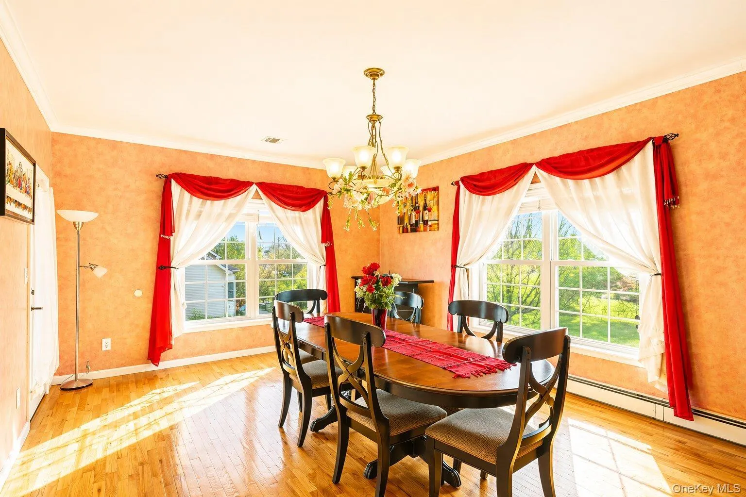 Dining room featuring hardwood flooring, crown molding, and two windows Dining room featuring hardwood flooring, crown molding, and two windows